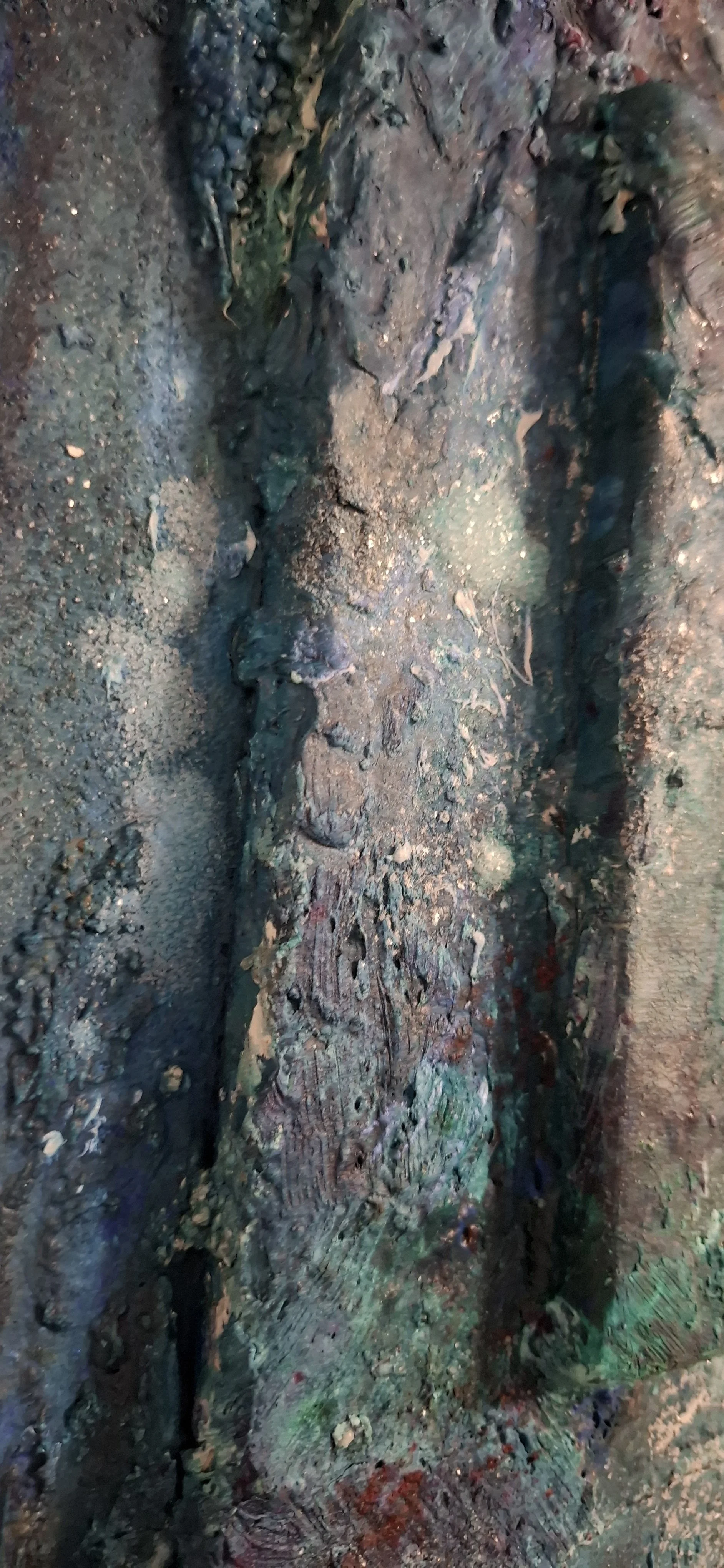 Nahaufnahme eines porösen Holzes, das mit verschiedenen Farben und Texturen bedeckt ist.