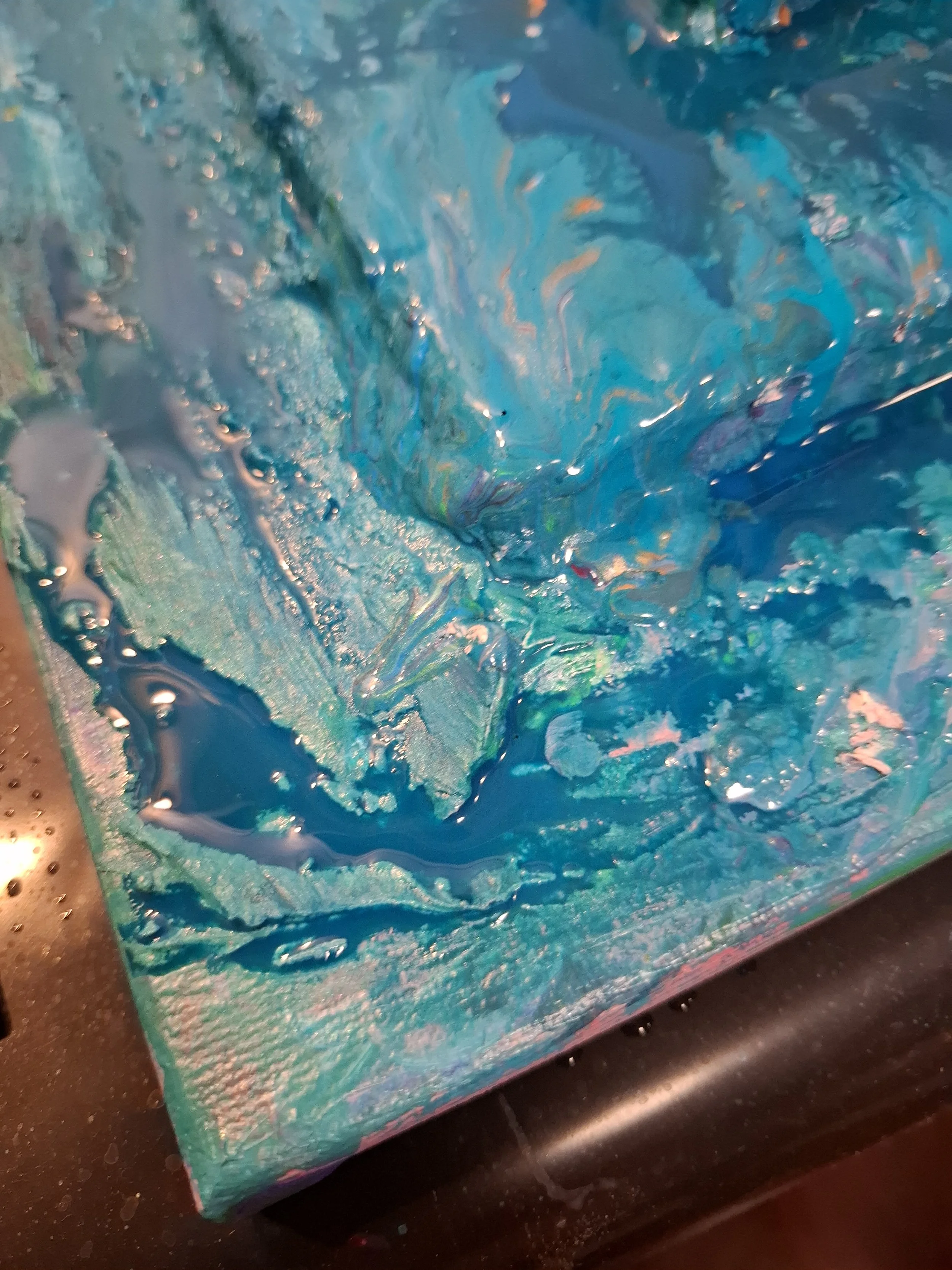 Abstrakte Gemälde mit blauen, grünen und silbernen Farben, die auf einer Leinwand verteilt sind.