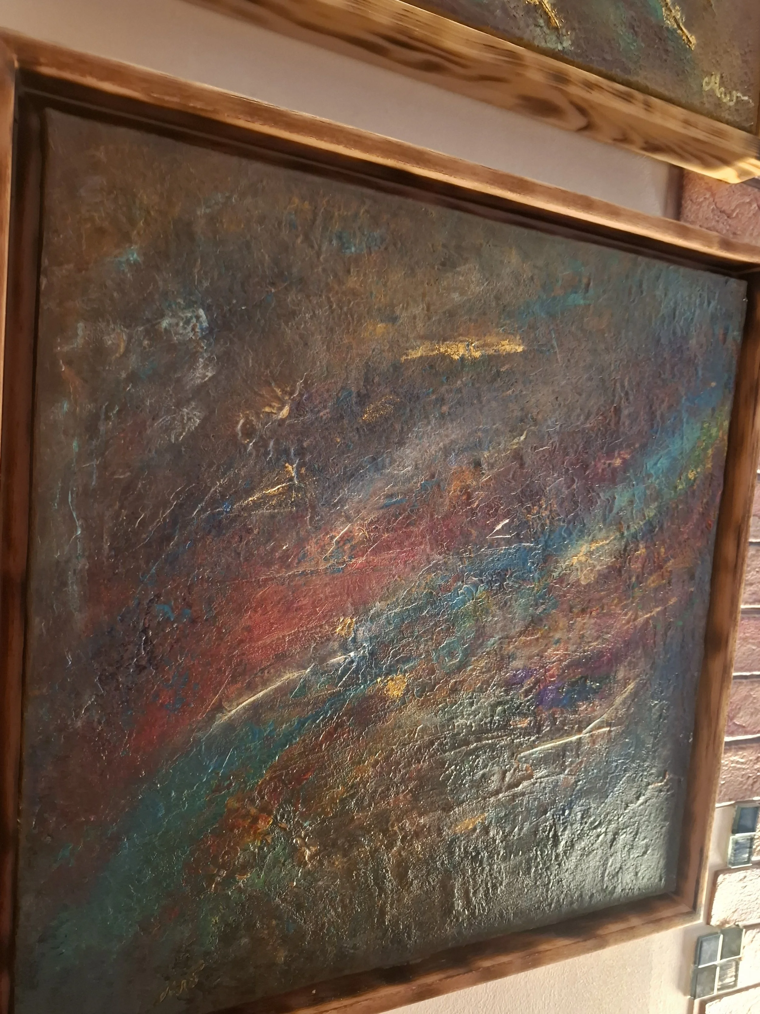 Abstraktes, farbenfrohes Gemälde mit Texturen in einem Holzrahmen.