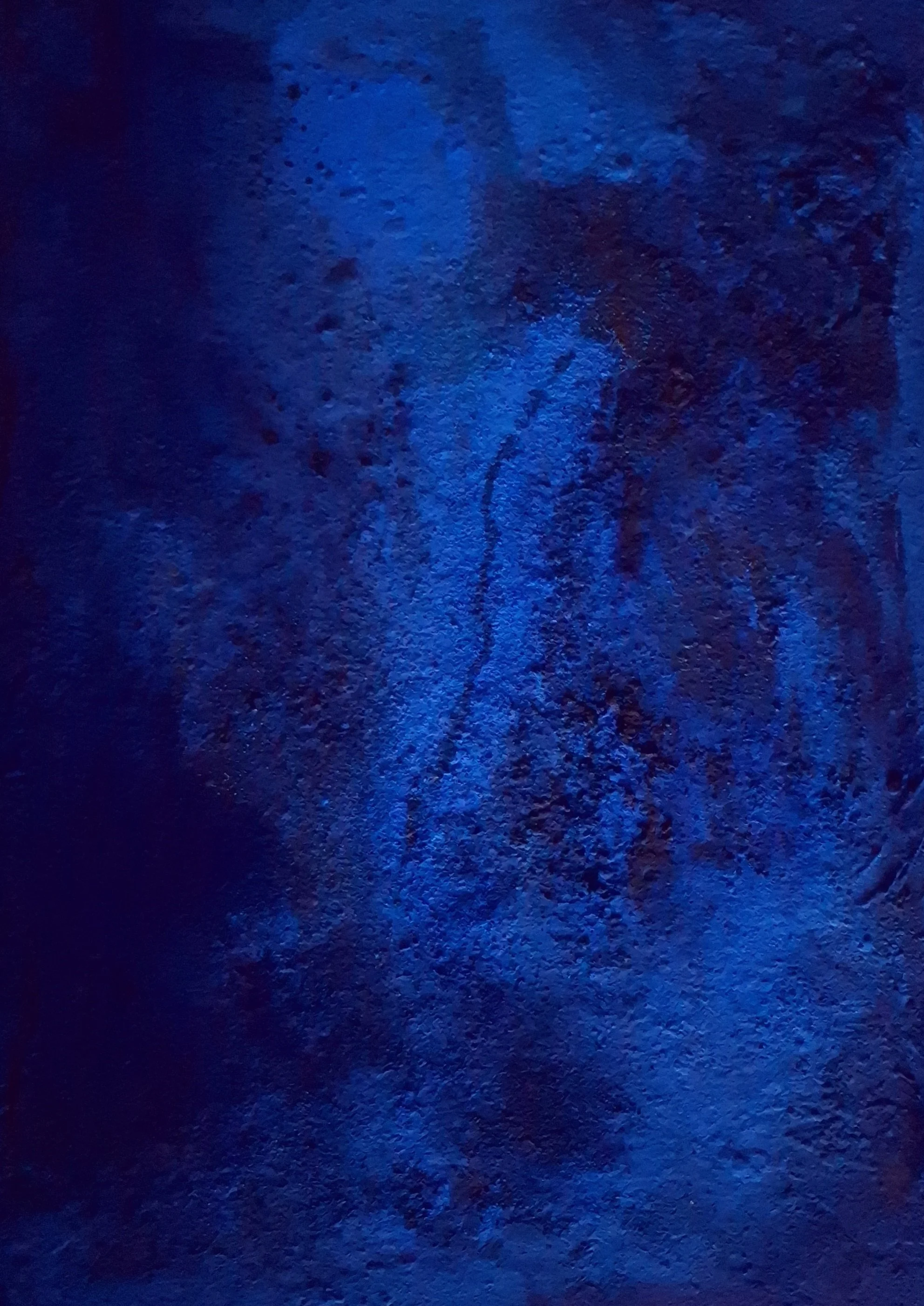 Dunkle, raue Oberfläche mit blauen Lichtern, die Schatten und Texturen betonen.