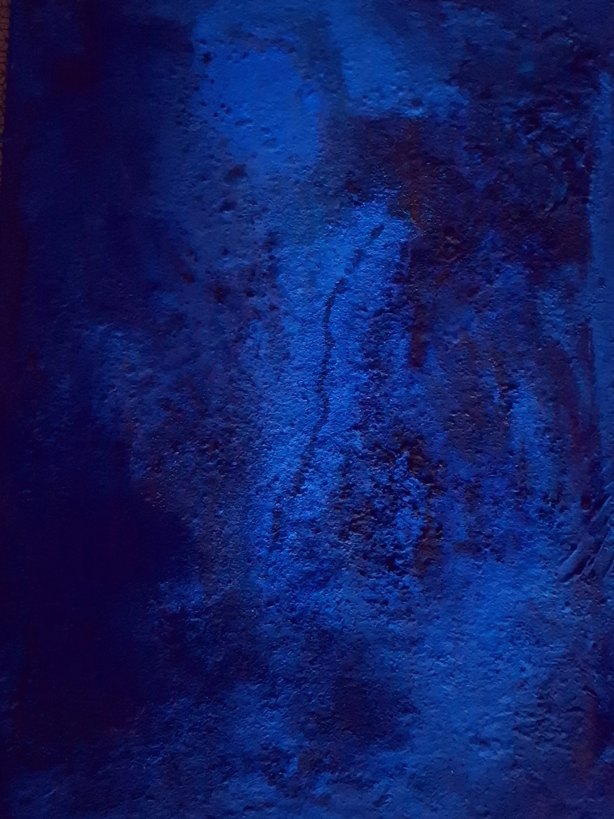 Dunkler, rauer Boden beleuchtet mit blauer Lichtquelle, fast schwarz mit bläulichen Akzenten