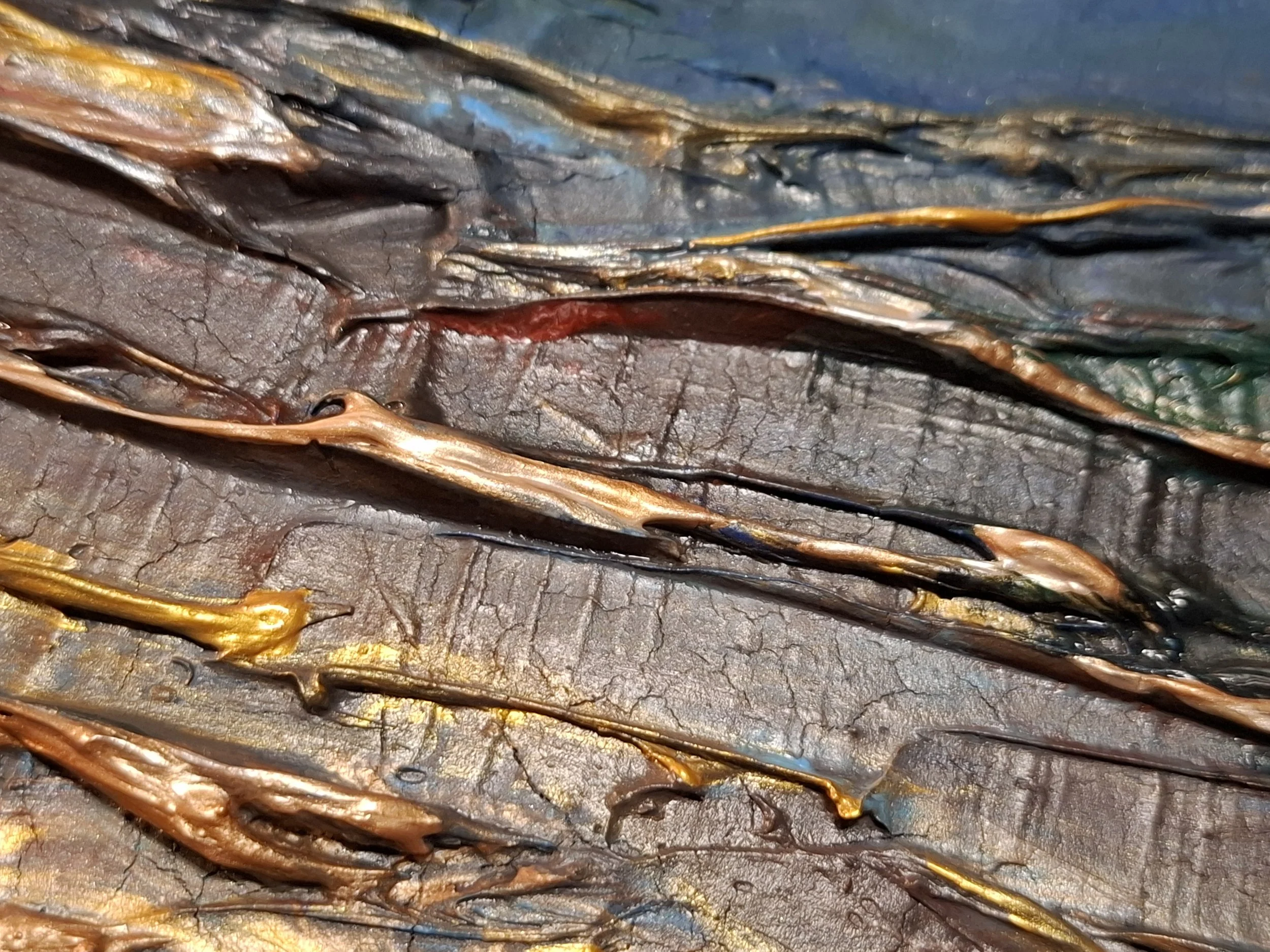 Nahaufnahme von verfärbtem, gewölbtem Metall mit verschiedenen Texturen und Farben, darunter Kupfer, Blau und Schwarz.