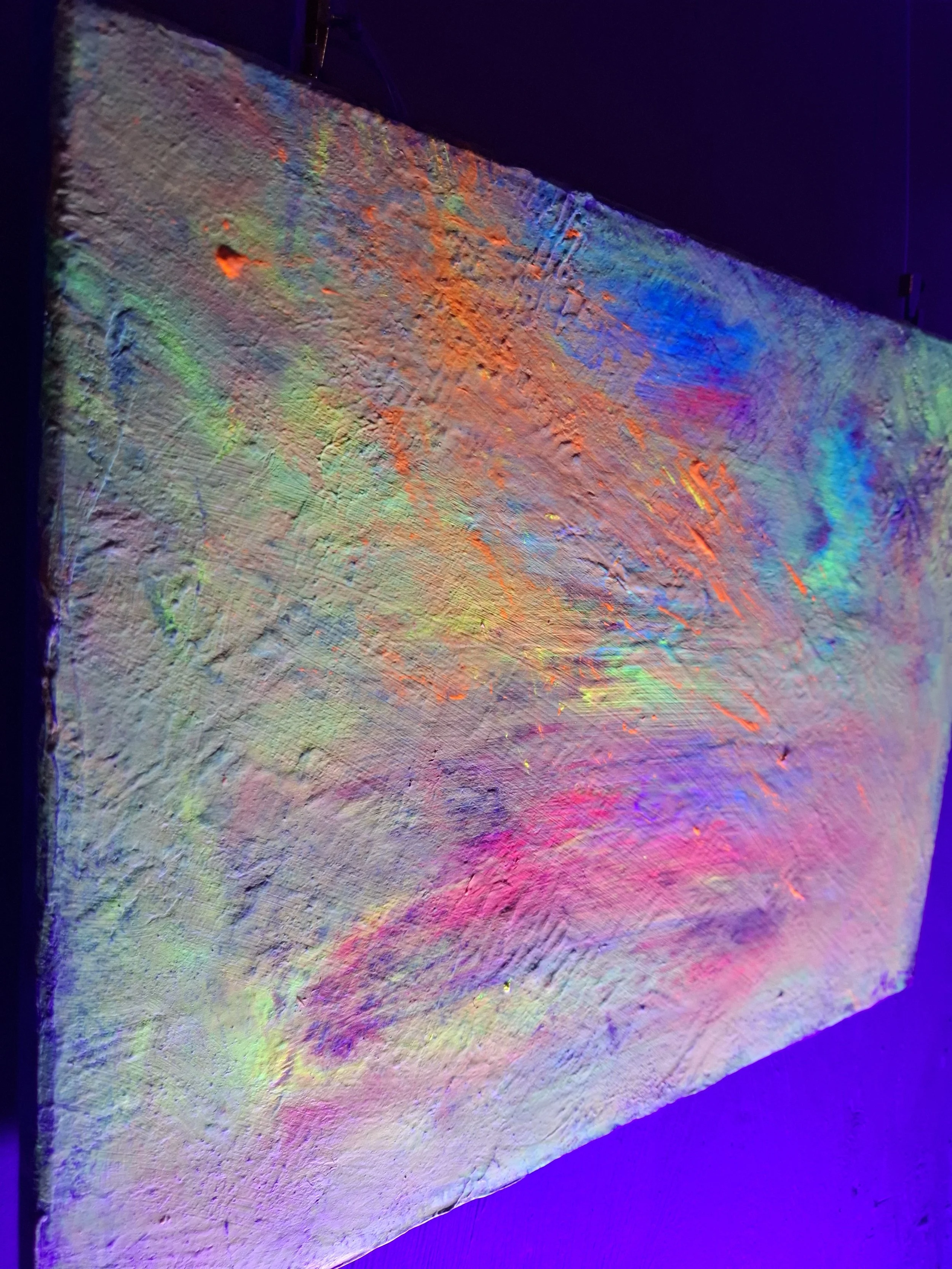 Abstraktes Gemälde mit leuchtenden, bunten Farben und einer texturierten Oberfläche unter Schwarzlicht, das die Farben zum Leuchten bringt.