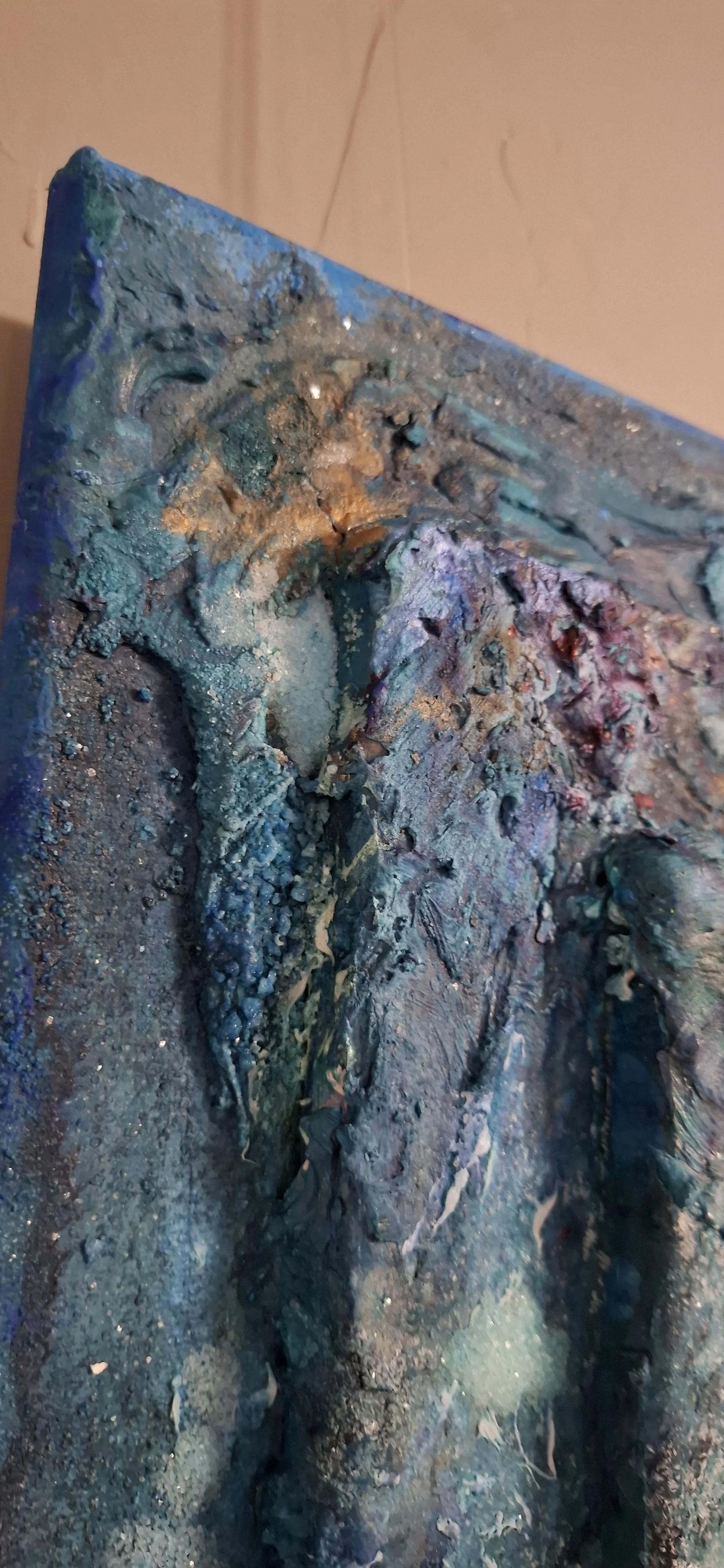 Nahaufnahme eines abstrakten Gemäldes mit dicken, texturierten Farbschichten in Blau, Grün, Violett und Gold