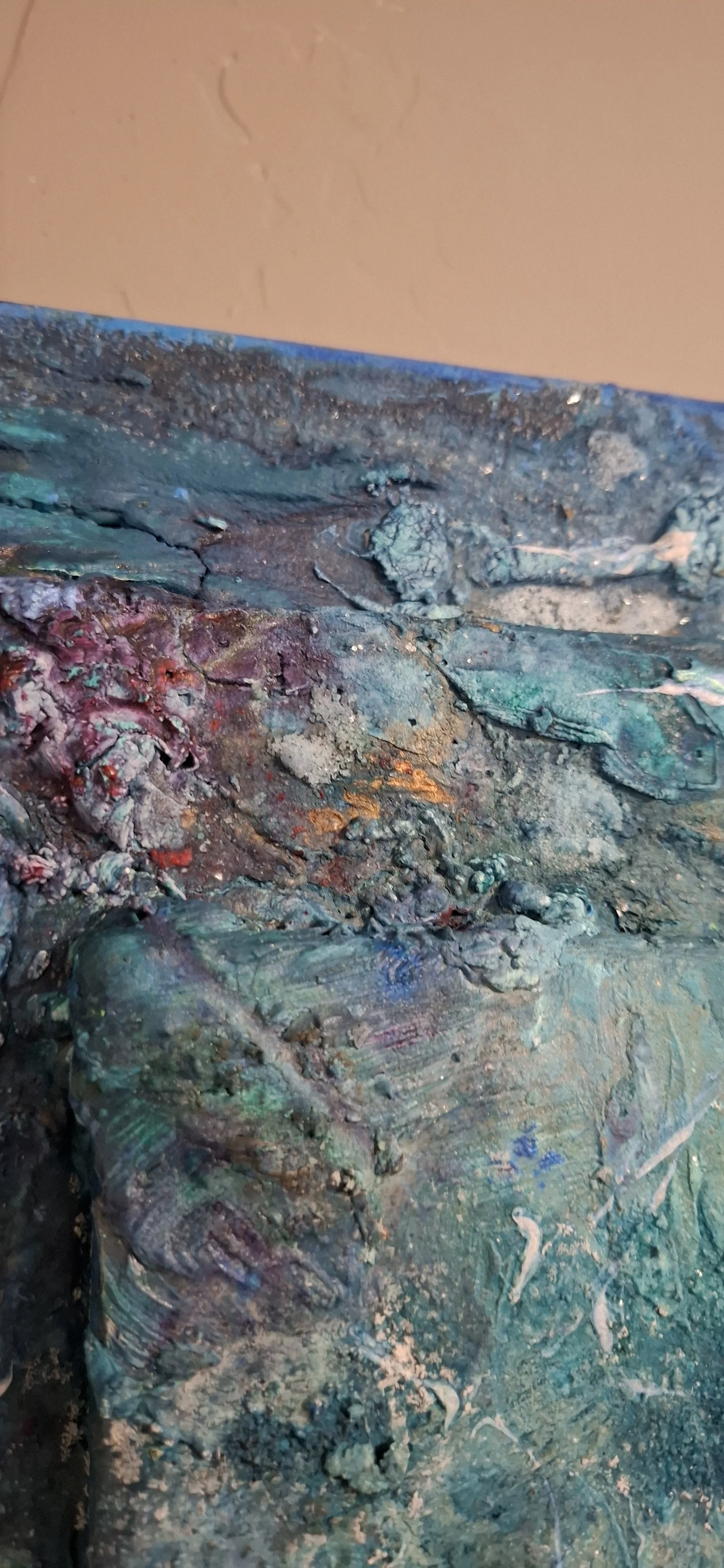 Eine Nahaufnahme einer bunten, strukturierte Oberfläche mit verschiedenen Farbtönen und Texturen, wahrscheinlich eine künstlerische Malerei oder eine Skulptur