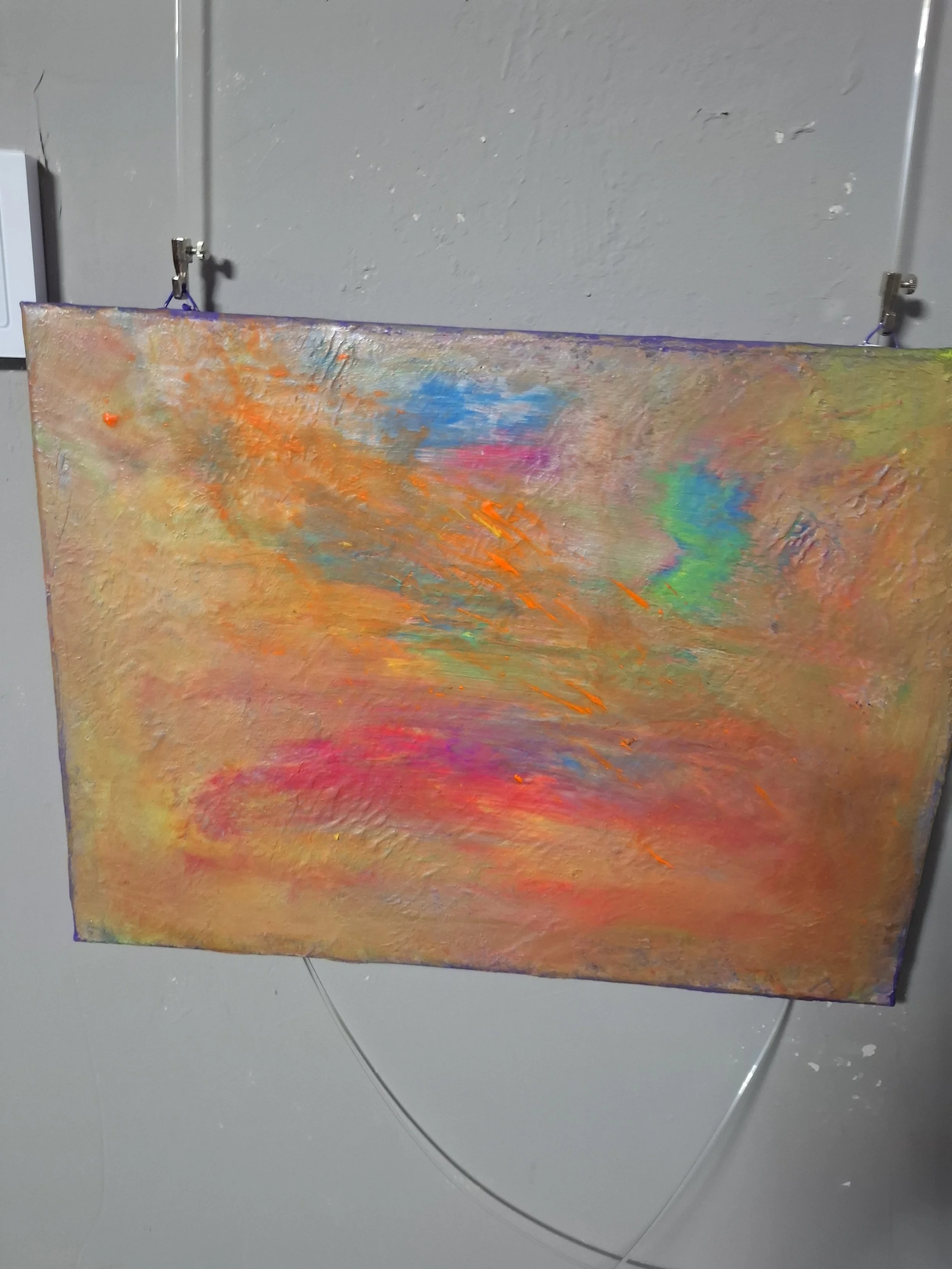 Abstraktes Gemälde mit leuchtenden Farben wie Orange, Pink, Blau und Grün, auf einer Leinwand, die an einer Wand hängt.