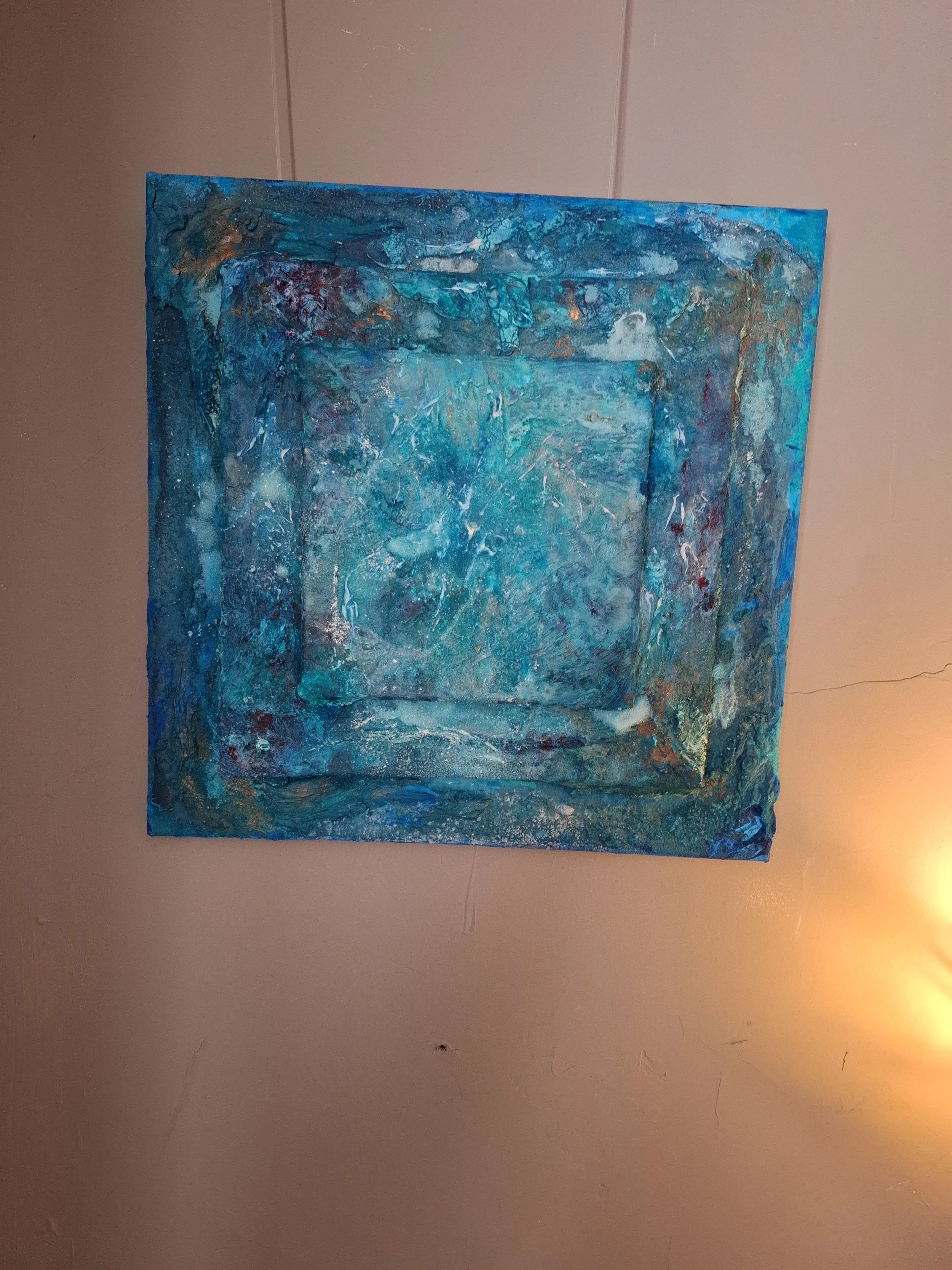 Abstraktes Gemälde in Blau- und Grüntönen mit Struktur und Textur, auf eine beige Wand gemalt.