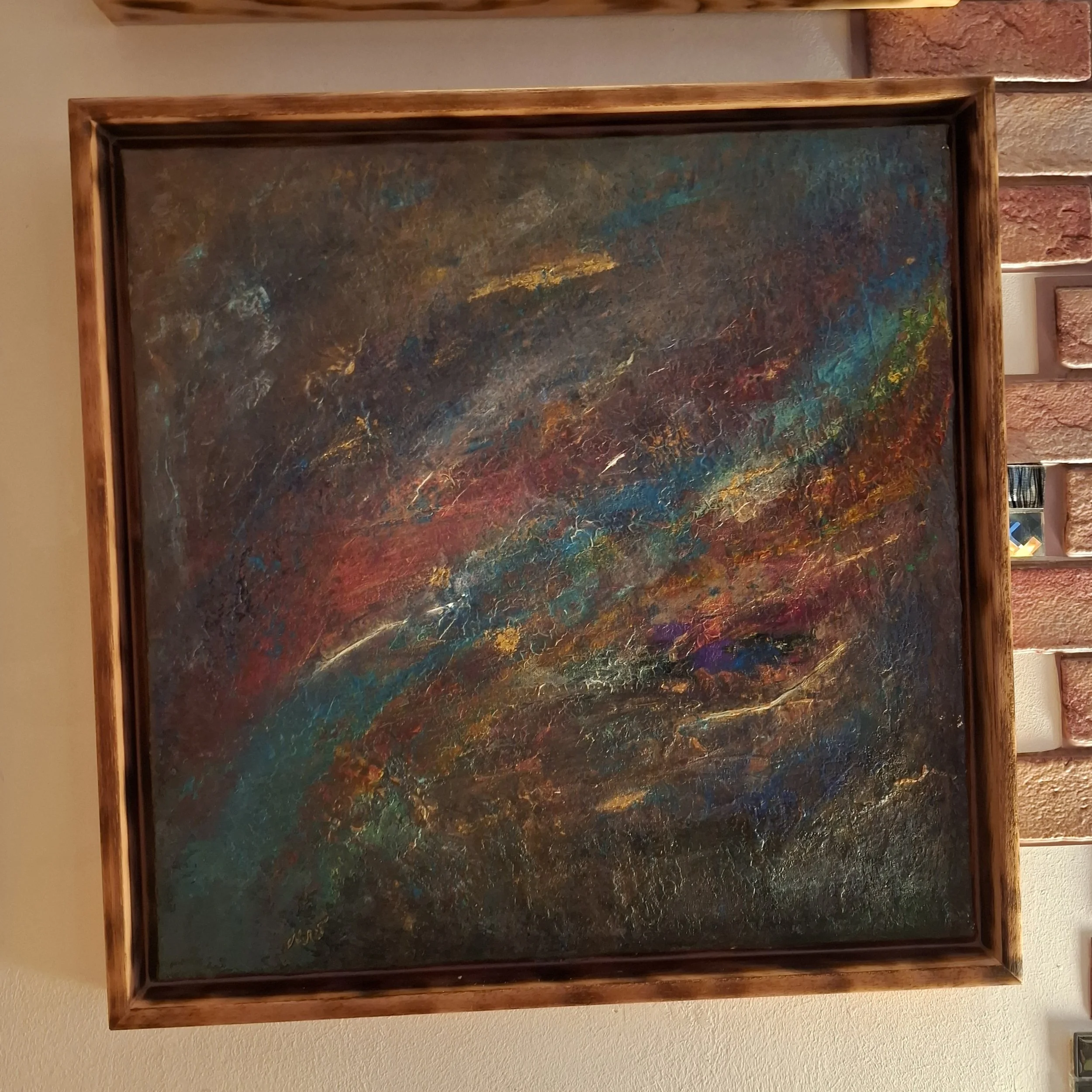 Abstraktes Gemälde mit bunten Farbschichten auf dunklem Hintergrund in einem Holzrahmen