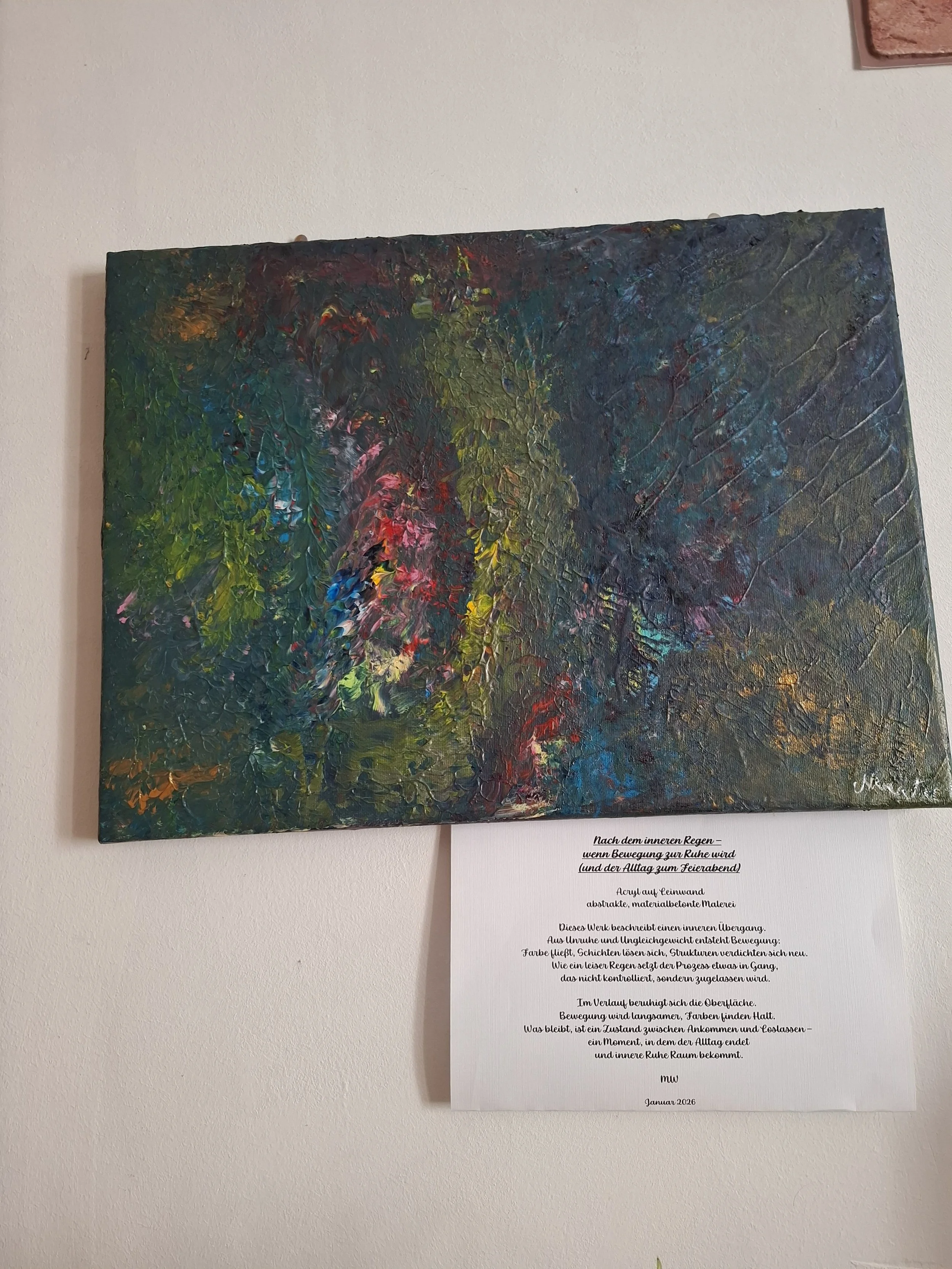 Abstraktes Gemälde mit vielfältigen Farben und Textur an einer Wand, darunter ein Textblatt mit poetischer Beschreibung.