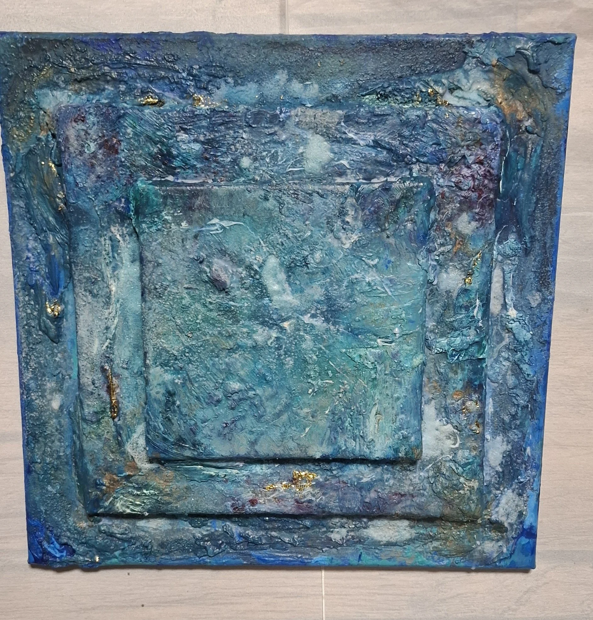 Abstraktes Gemälde in Blau- und Goldtönen mit texturierter Oberfläche.