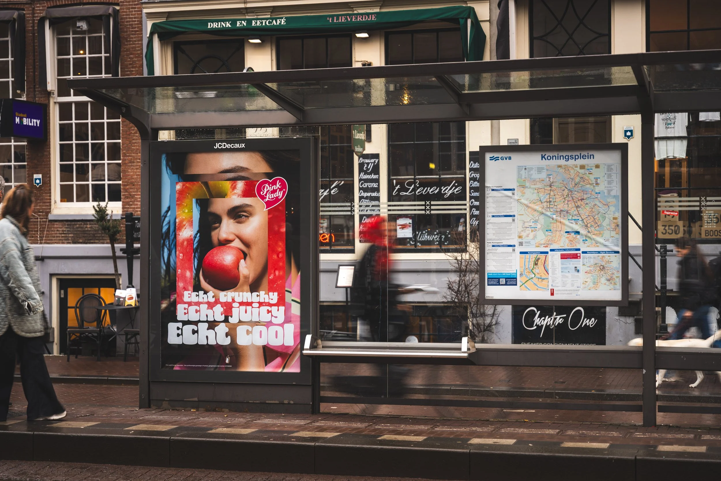 Een bushokje met advertenties en een stadsplattegrond in Amsterdam, Nederland.