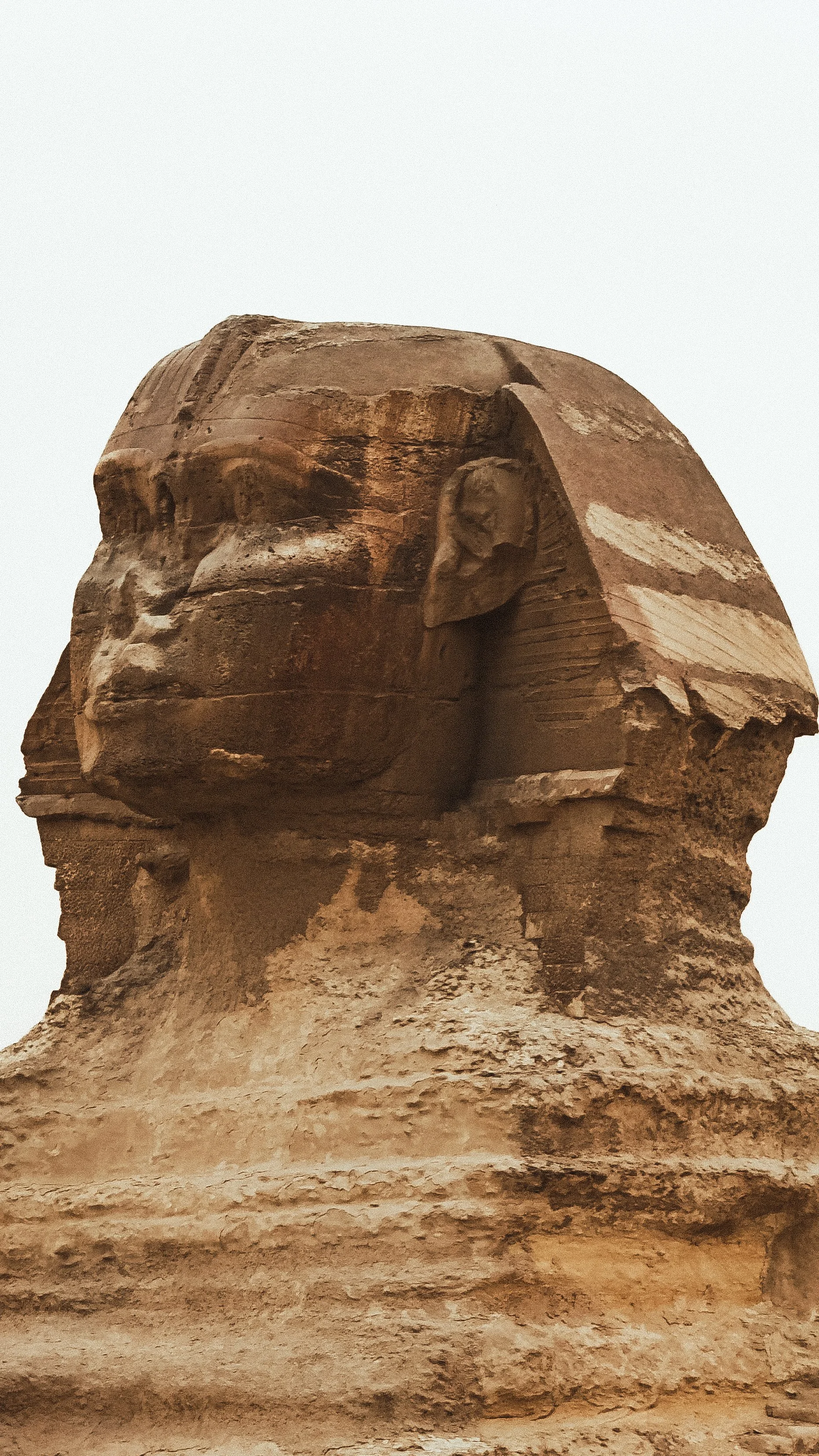 De afbeelding toont een grote oude pharao's kop standbeeld bewerkt uit steen.