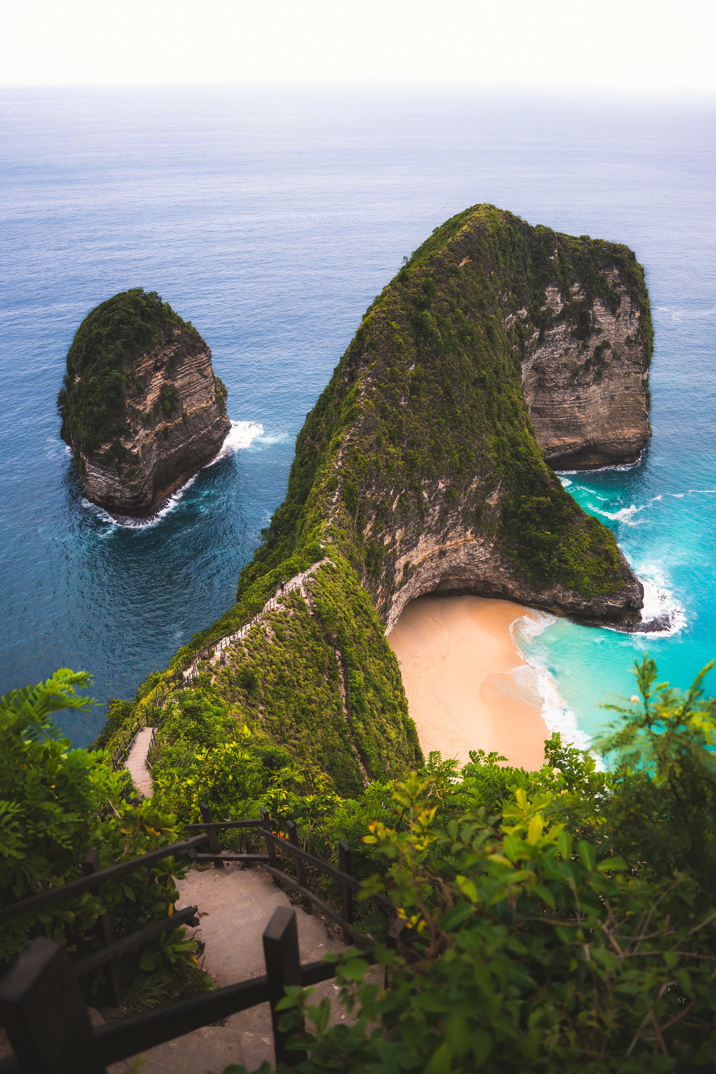 Uitzicht op een tropisch eiland met zandstranden, groene kliffen en hetheldere blauwe water van de oceaan.