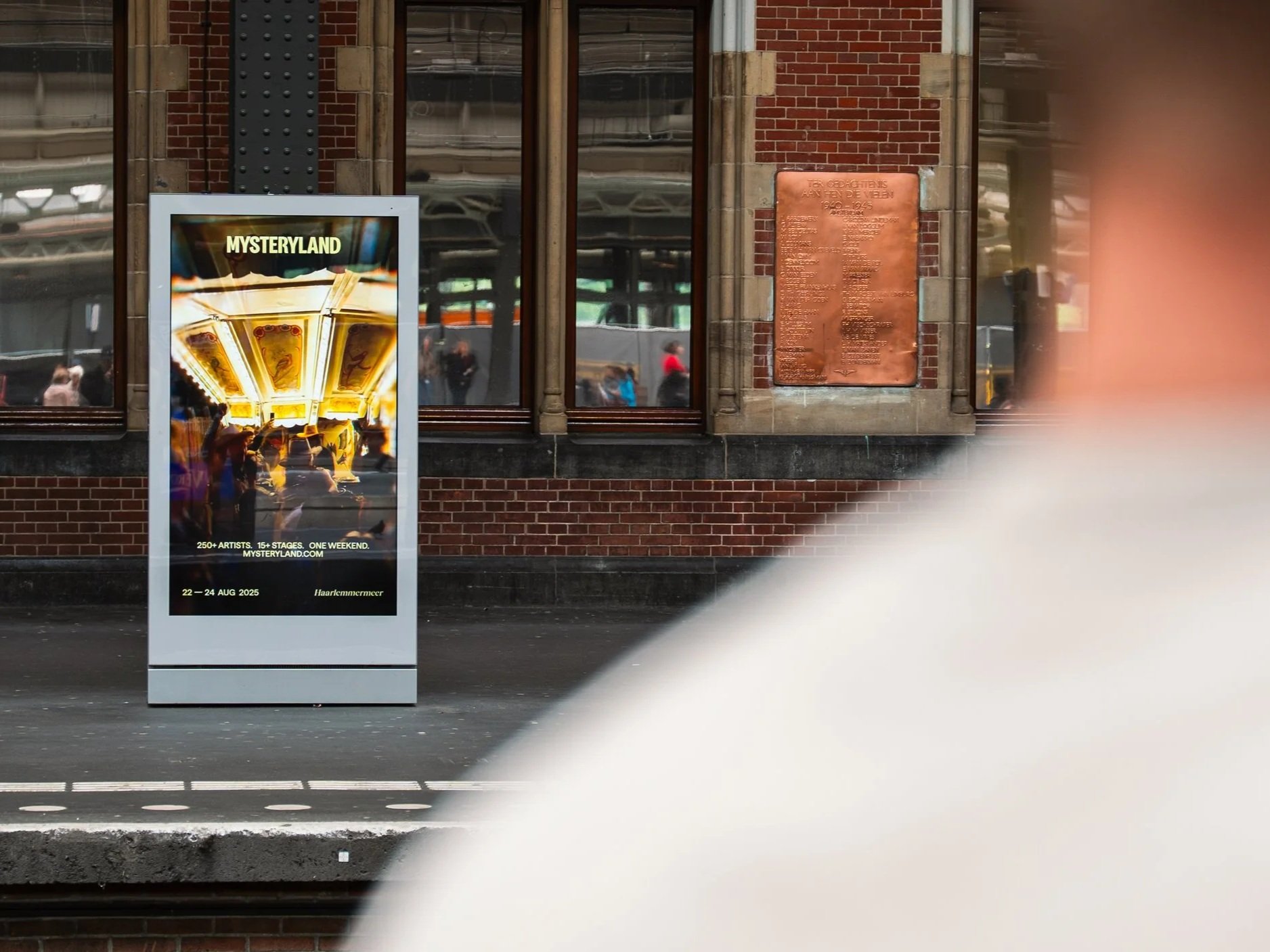 Poster voor het muziekfestival Mysteryland met een foto van een attractie in een attractiepark en tekst over het evenement dat plaatsvindt van 22 tot 24 augustus 2025 in Haarlem.
