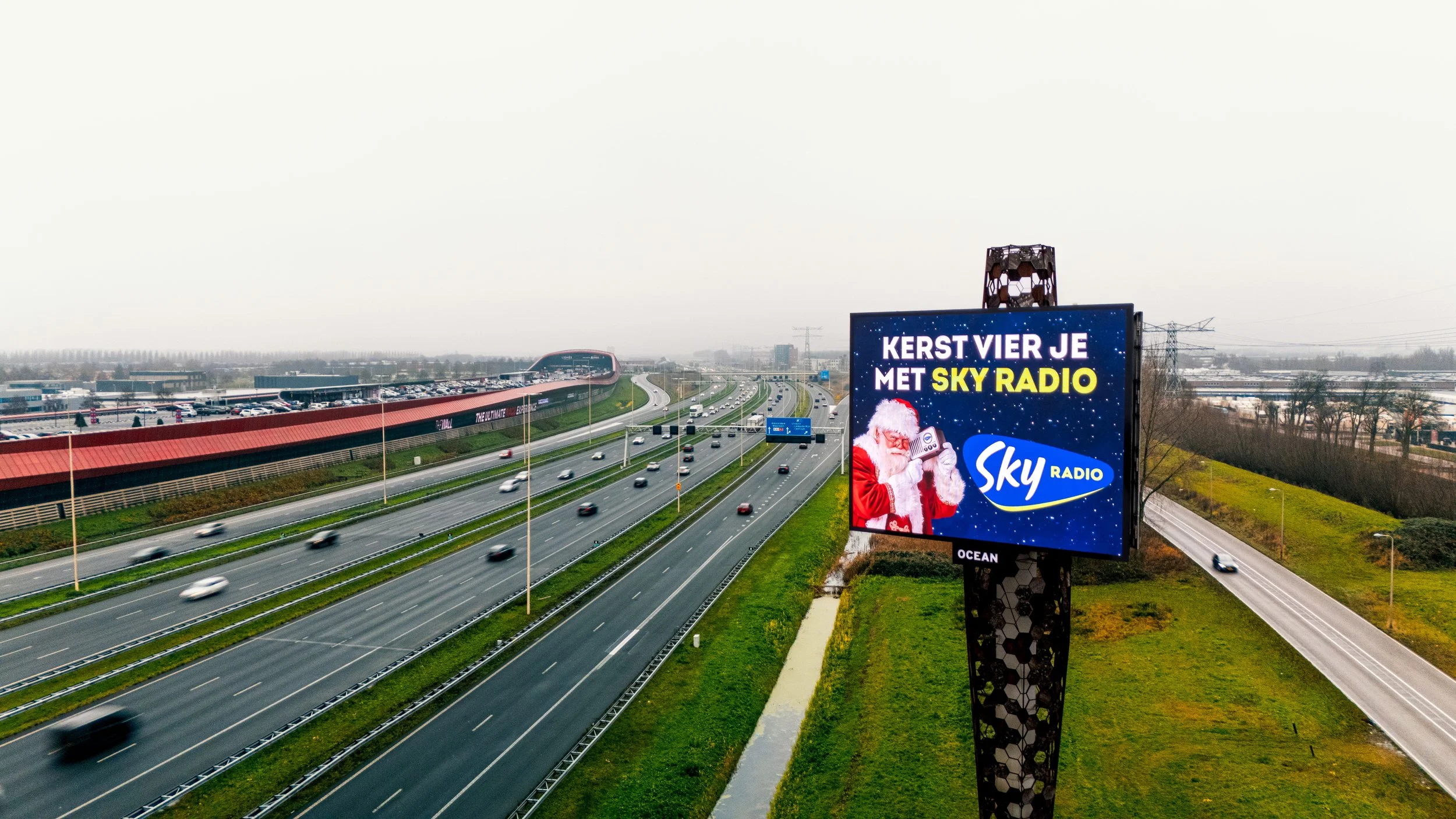 Billboard langs de snelweg met een kerstgroet, een kerstman en Sky Radio advertentie.