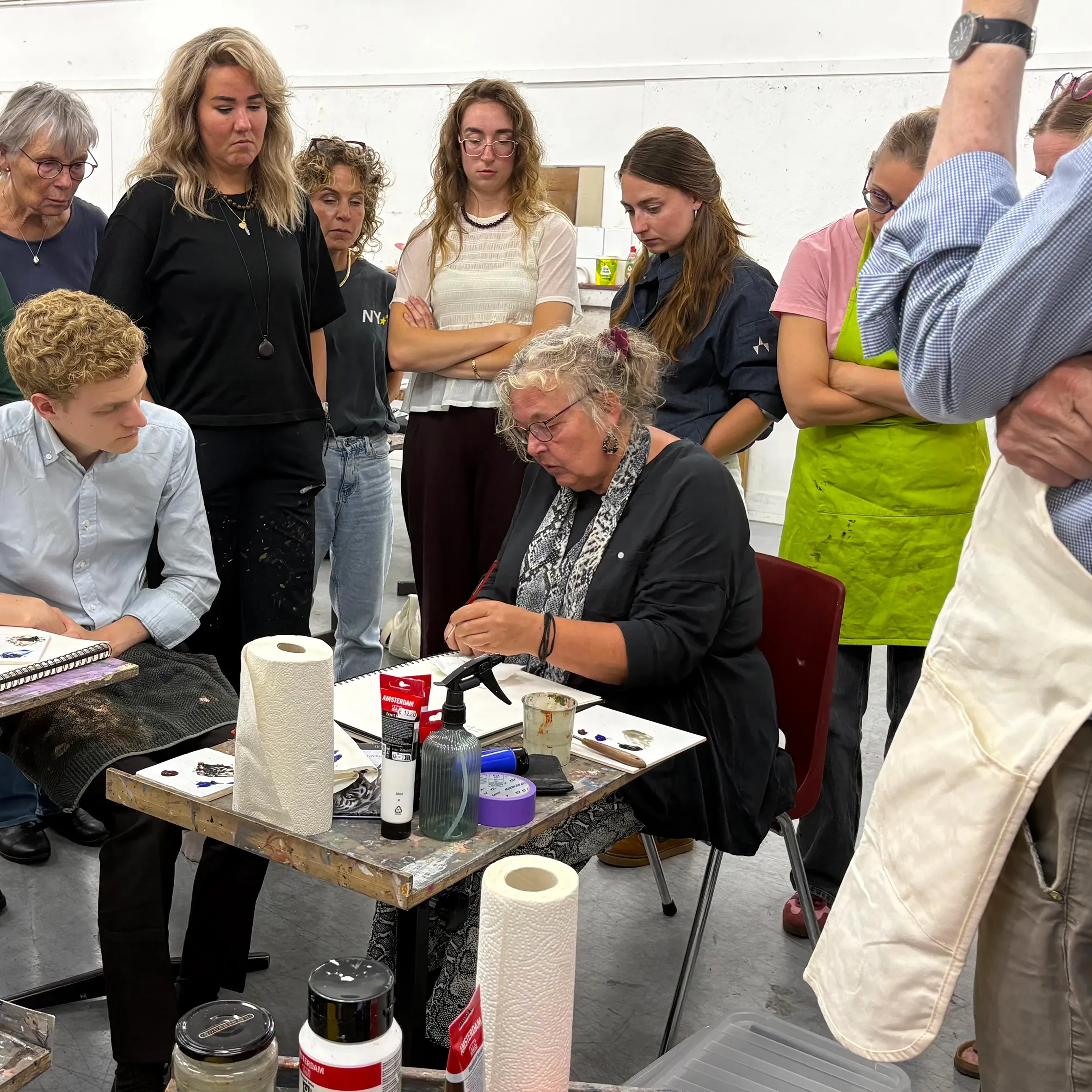 Docent Anuschka de Smidt demonstreert studenten Vakscholing 2 hoe je met acrylverf verschillende tonen van een kleur kunt weergeven