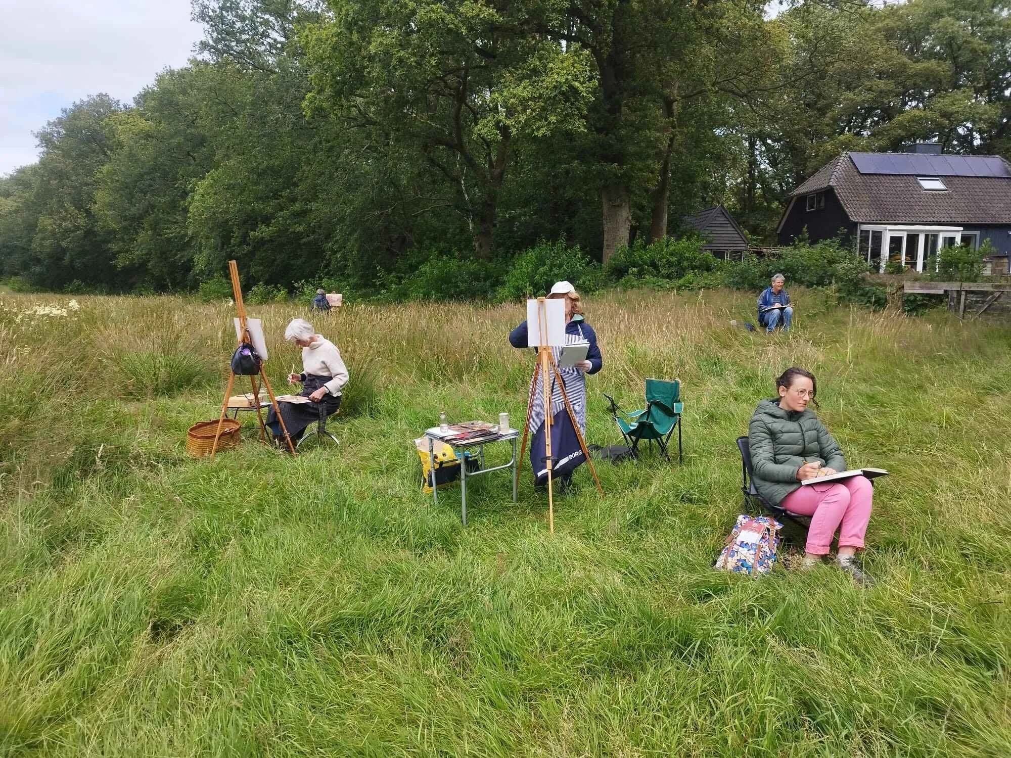vier studenten nemen schilderend deel aan de workshop buitenschilderen