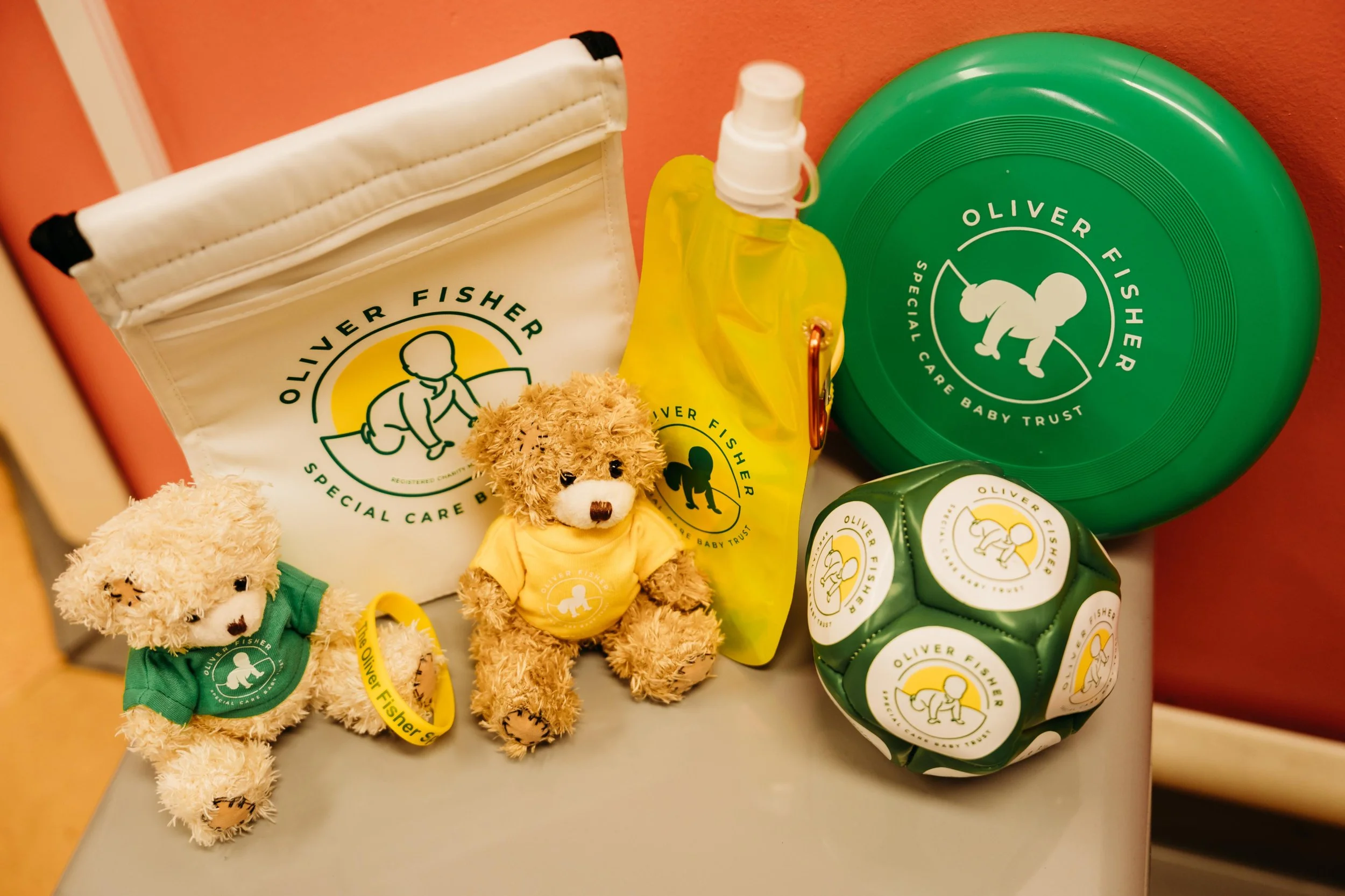 Selection of charity merchandise including teddy bears bags and branded fundraising items