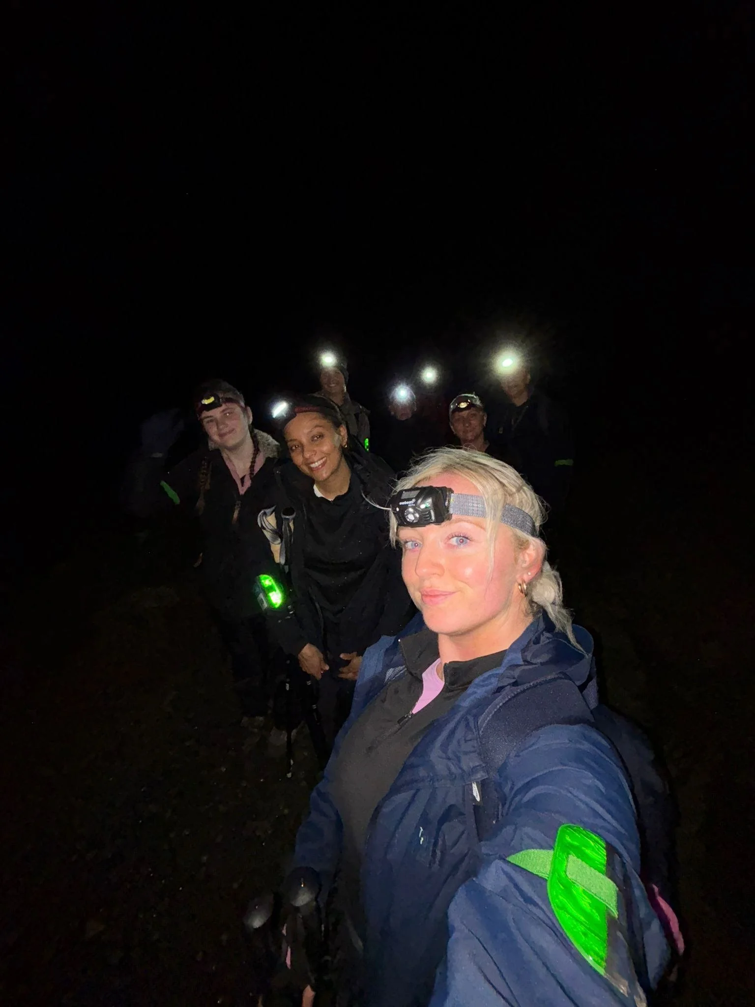 Group of participants wearing head torches during a night-time charity challenge