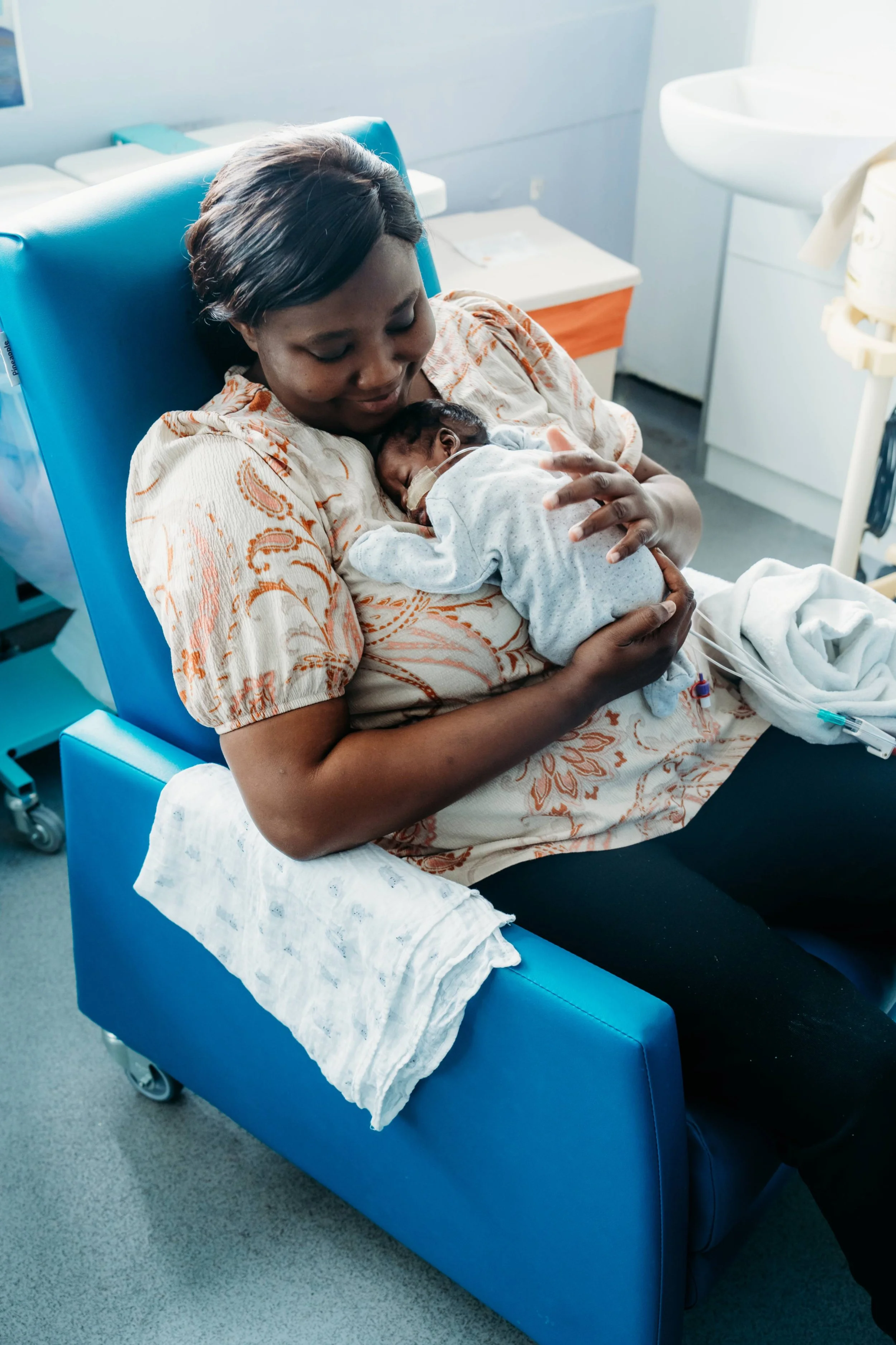 Parent gently holding their newborn baby showing moment of care and connection in hospital setting