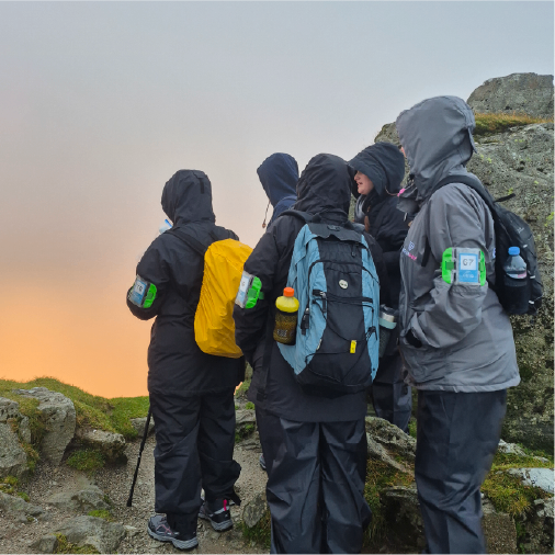 Group of people walking together taking part in outdoor charity fundraising challenge event