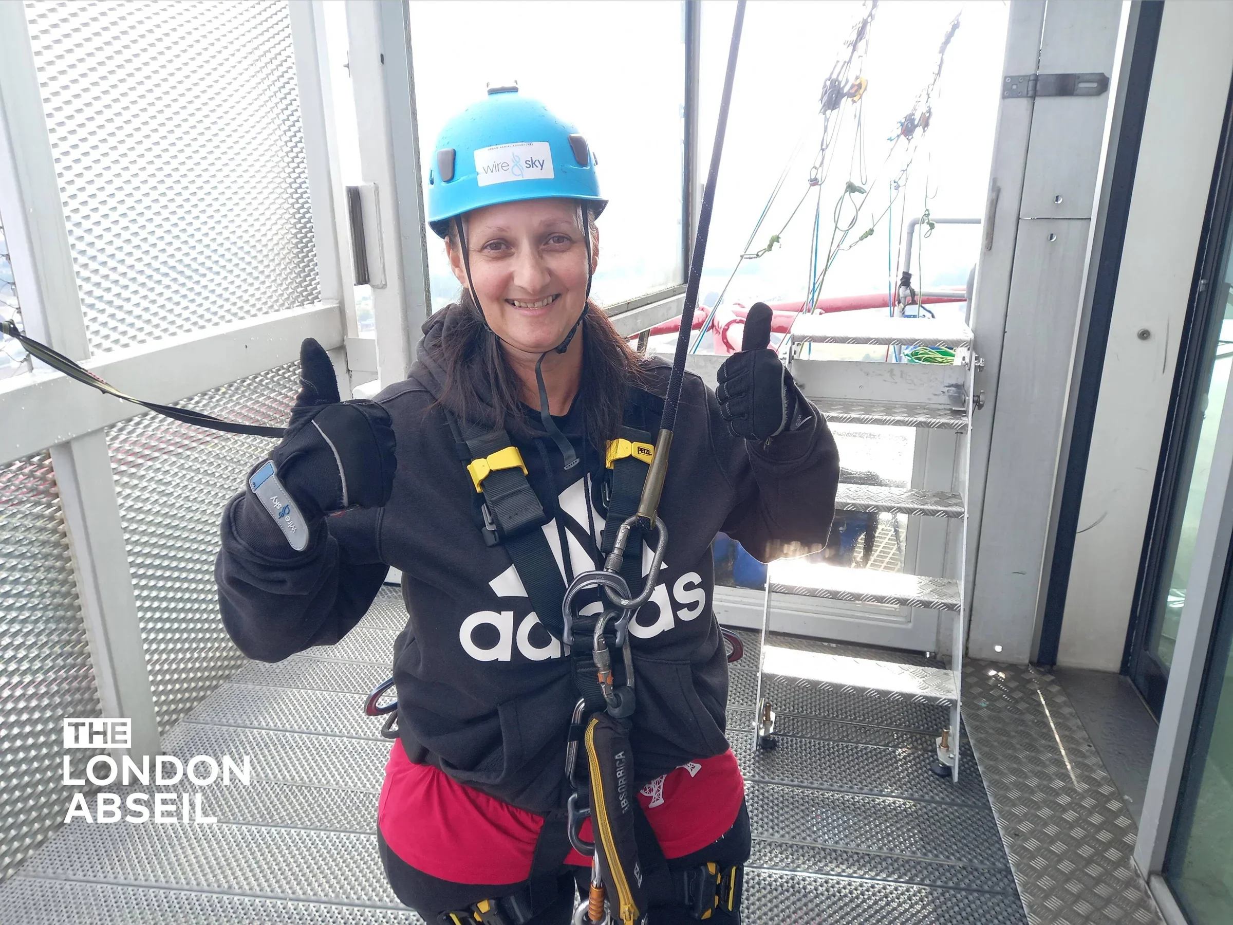 Photo of a women wearing a harness and blue hard hat, ready to take on a challenge