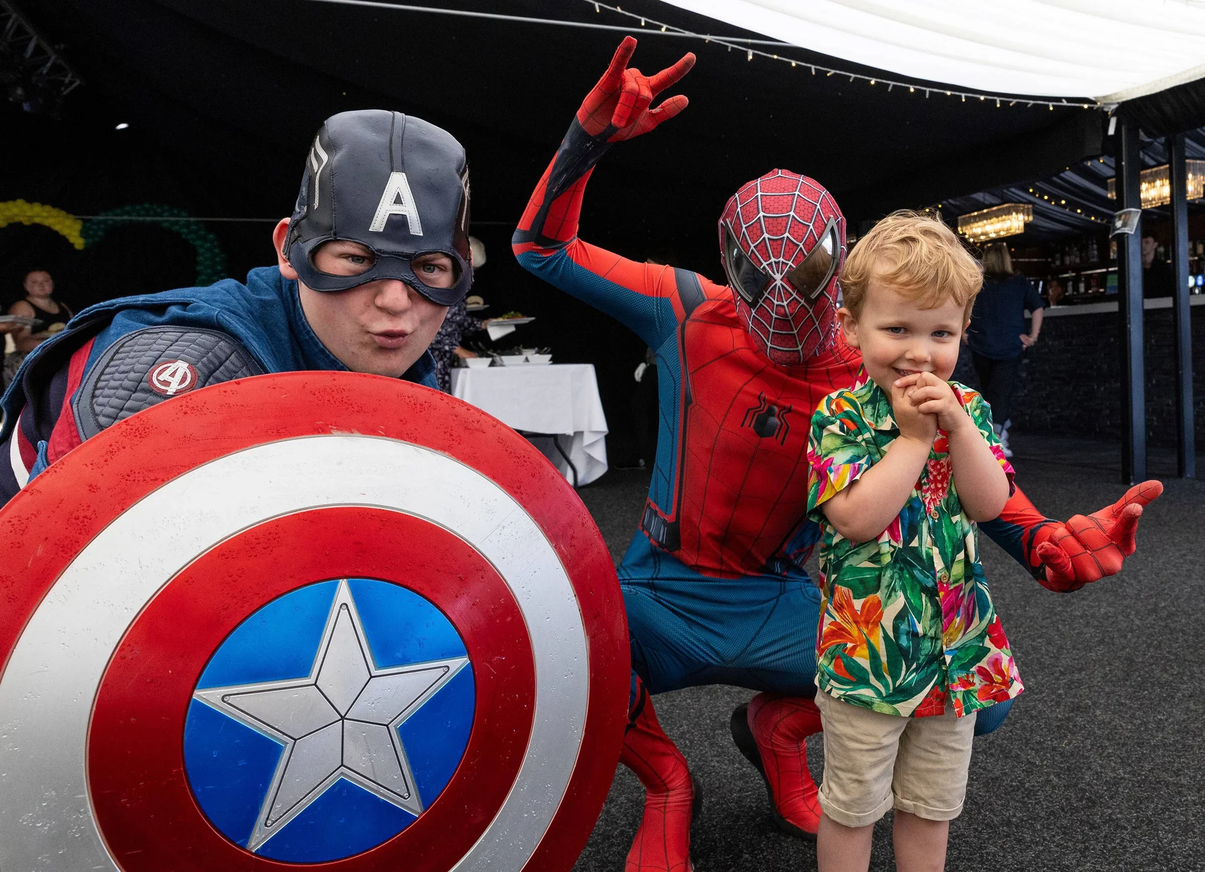 Photo of a child meeting with Captain America and Spiderman