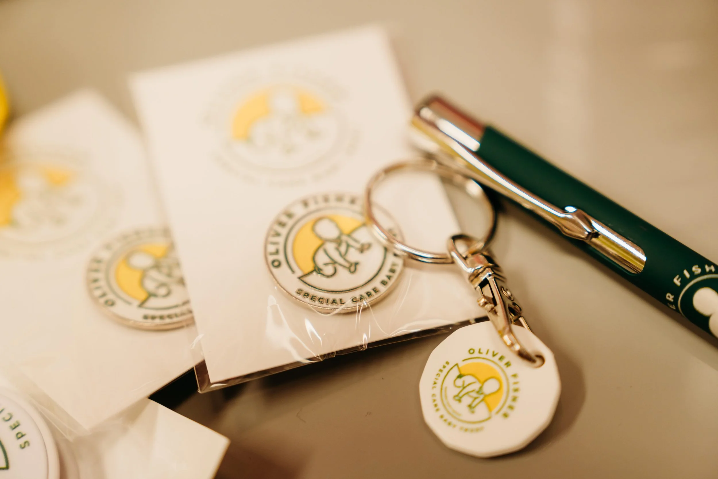 Close-up branded keyring pen, and pin badge