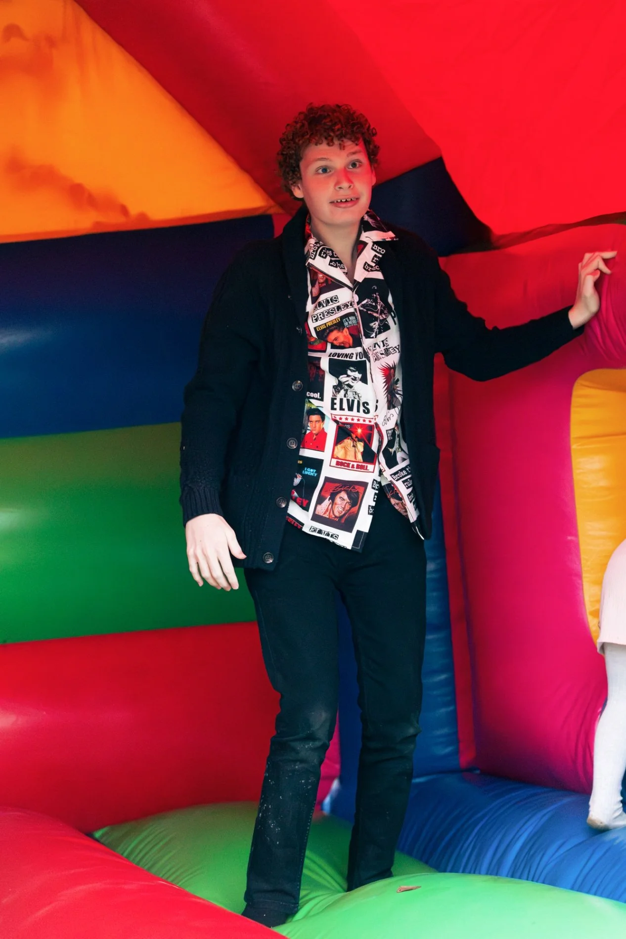 Boy standing inside colourful inflatable at community fundraising event