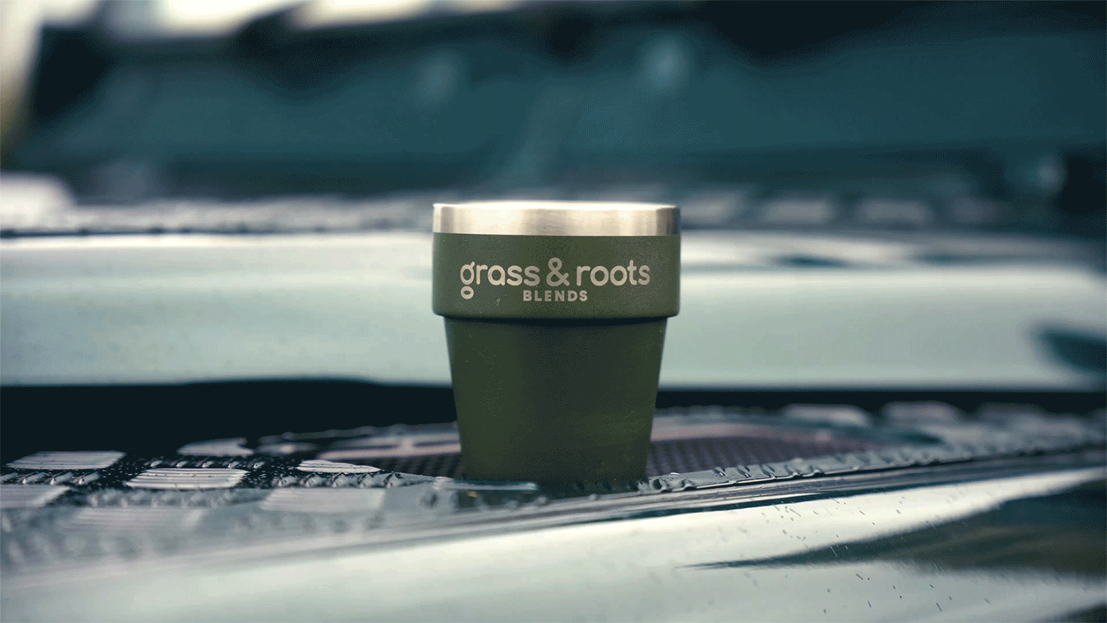 A grass & roots tumbler with a warm, steaming coffee inside