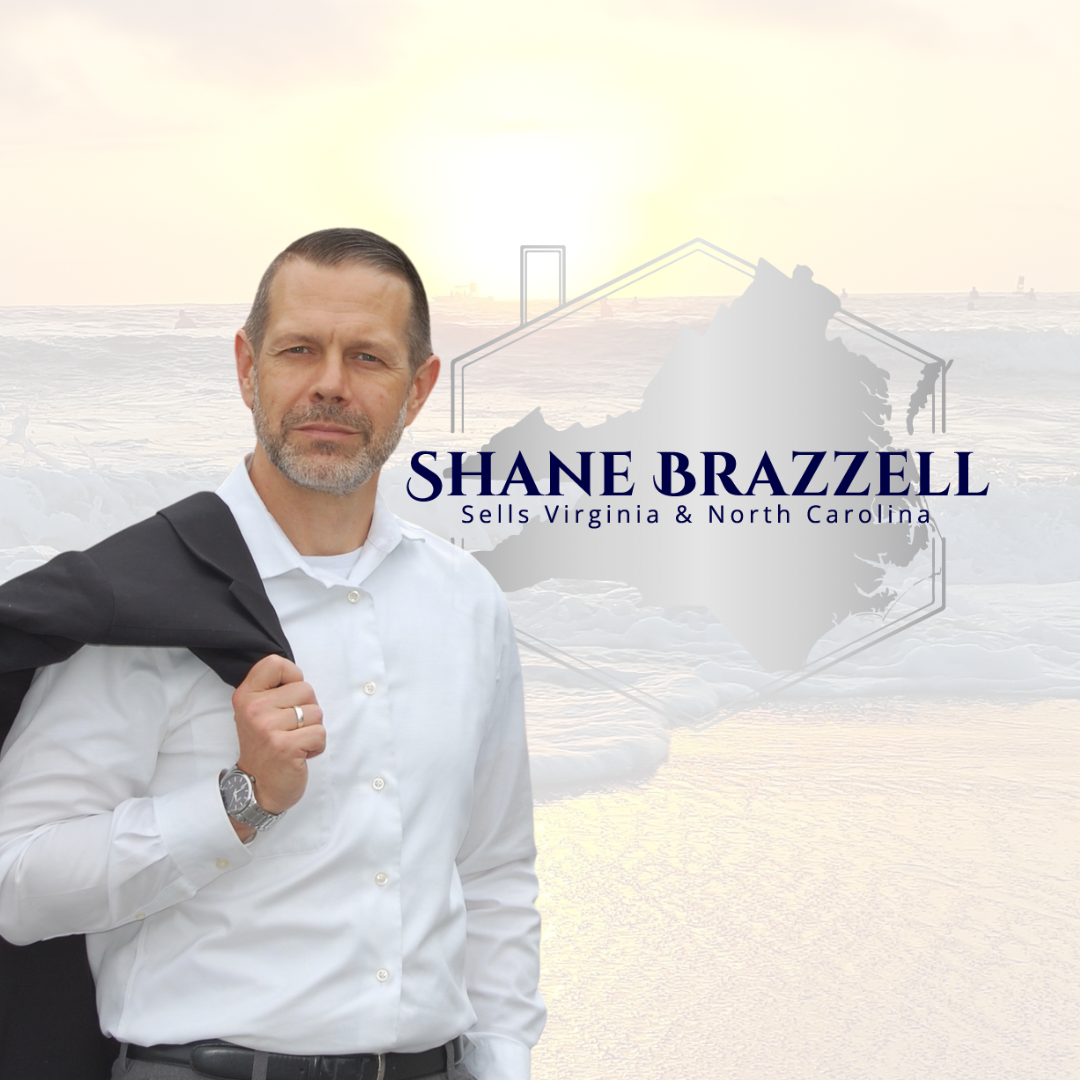 Portrait of a man in a white shirt holding a black jacket over his shoulder, standing on a beach at sunset with a campaign sign for Shane Brazzell, who sells in Virginia and North Carolina.