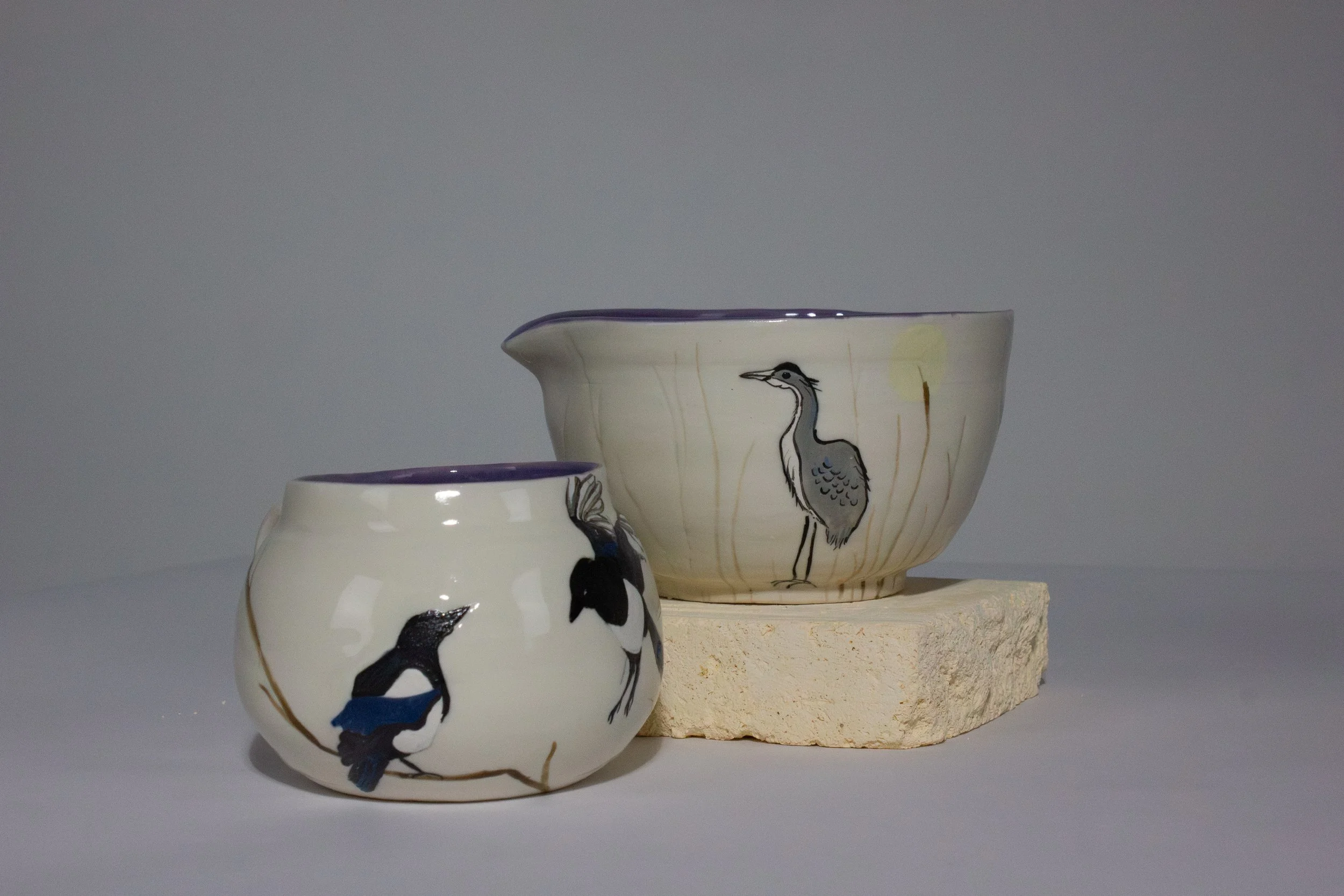 "Two Magpie Mug" (Right) and ""Blue Heron Bowl" (Right), 2026