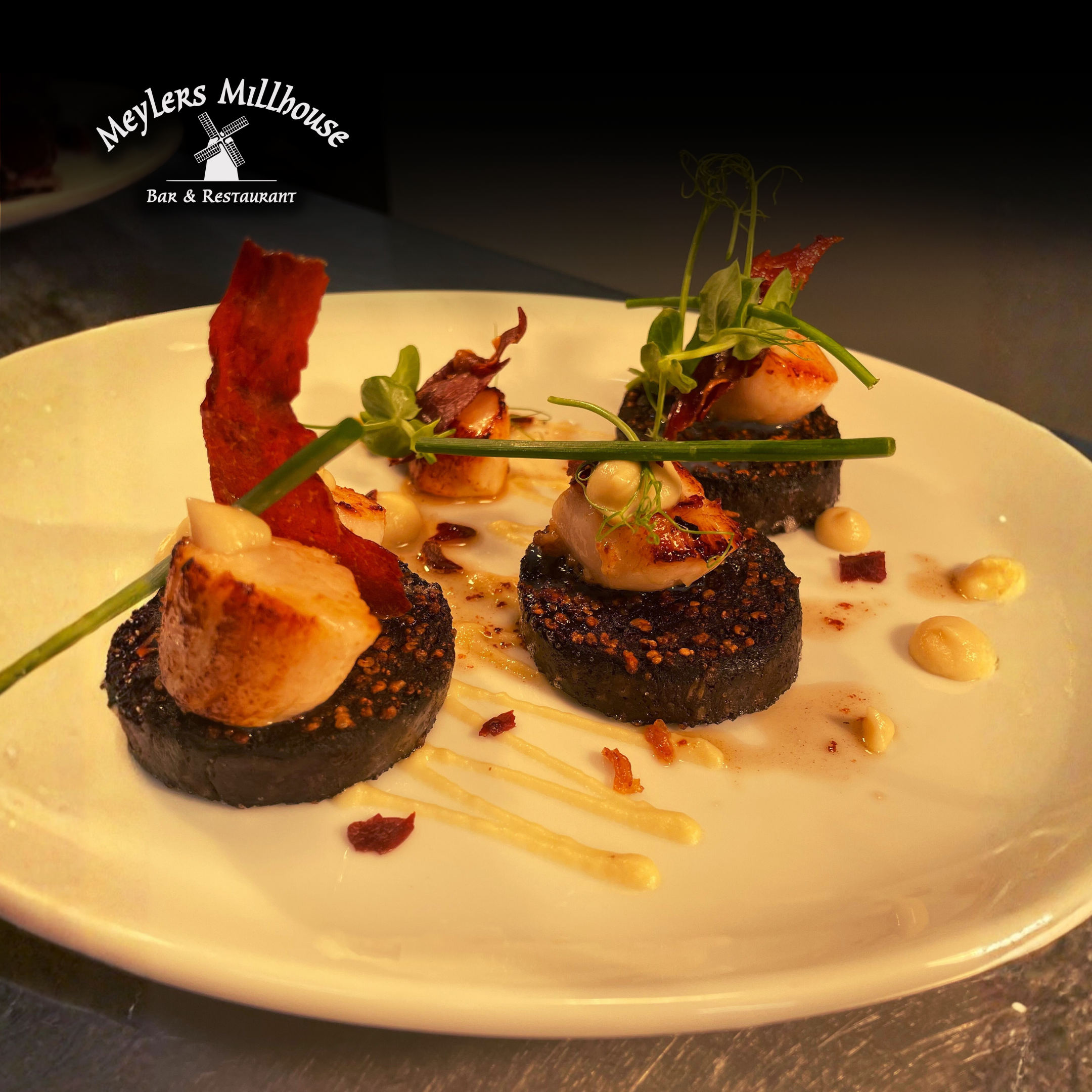 Pan Seared Scallops on Black Pudding, with a Parsnip Purée, Parma Ham Crisp and Pan Butter