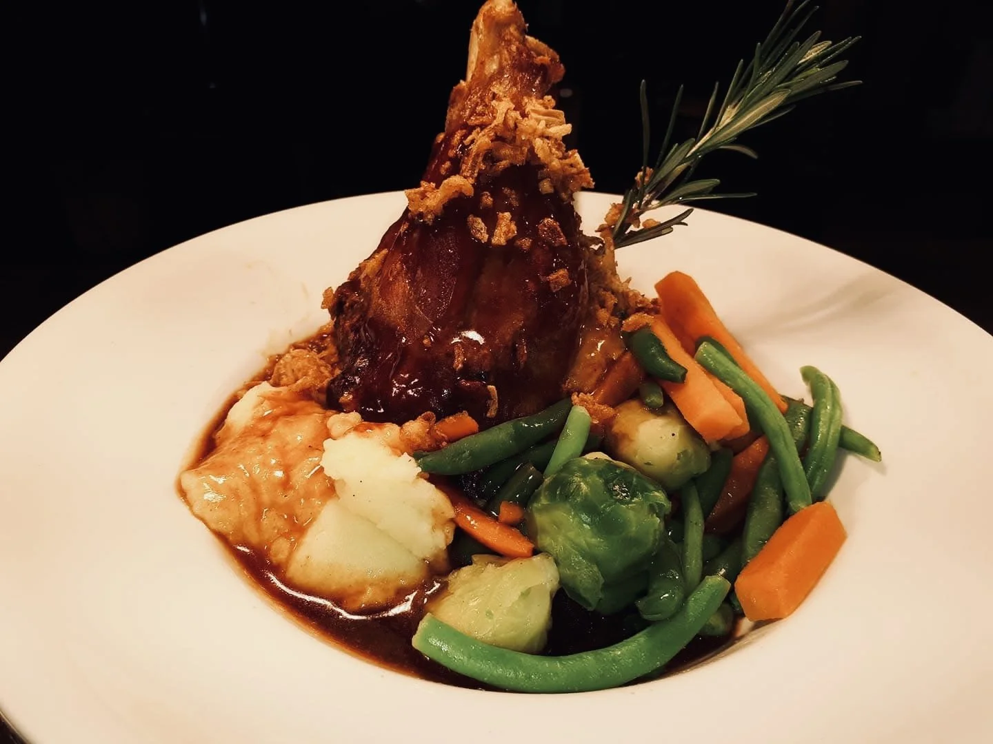 Braised Lamb Shank, with crispy shallots on a bed of Creamed Mashed Potatoes