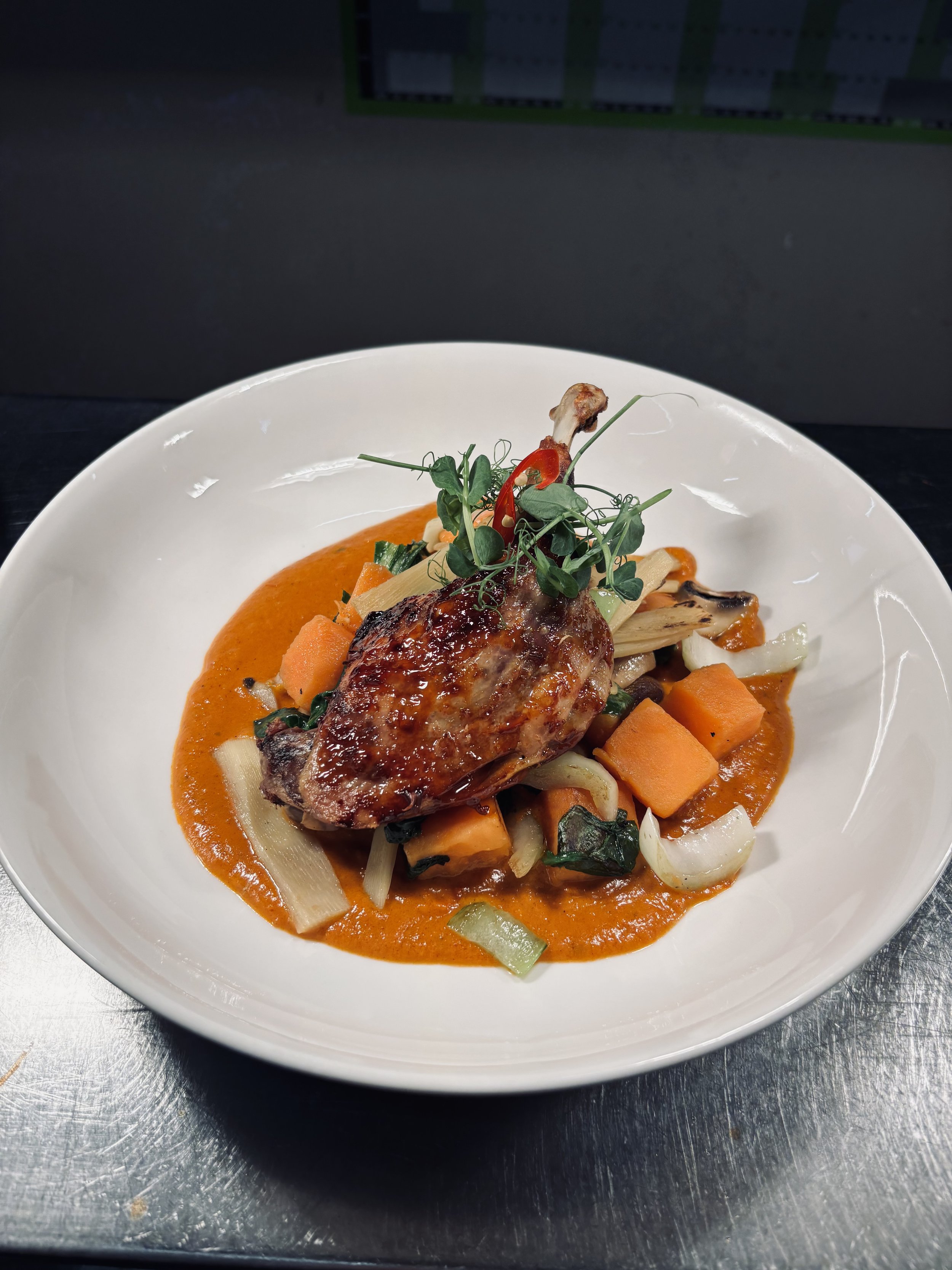 Confit Duck Leg, on a bed of Mushrooms, Spinach, Sweet Potato and Pak Choi with Tom Yum sauce.