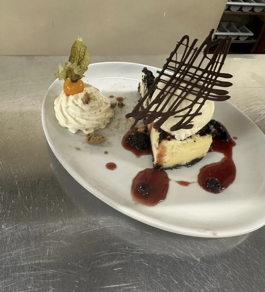 Homemade Cookies and Cream style Cheesecake with berry coulis and whipped cream