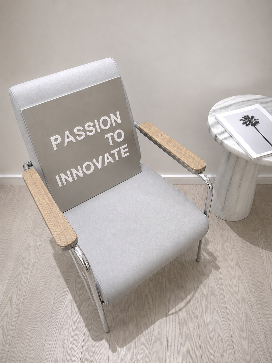 Chaise en métal et bois avec une pancarte affichée dessus disant "Passion to Innovate", à côté d'une table ronde avec une photo d'une palmière.