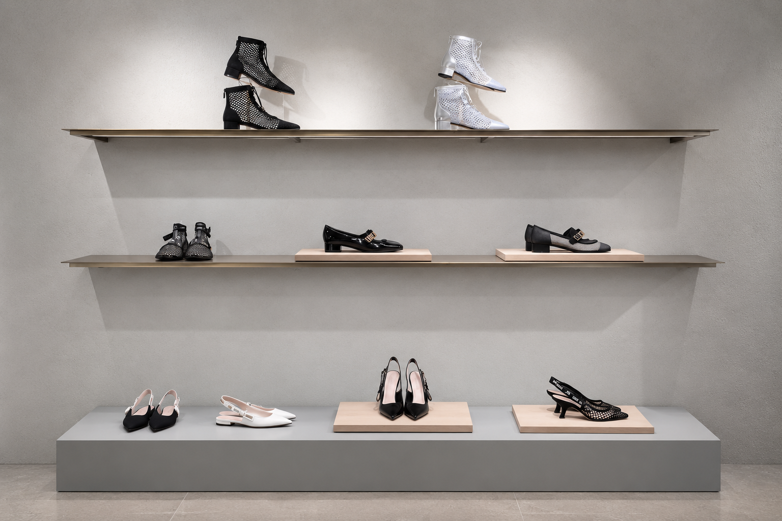 Vitrine de chaussures élégantes en noir et blanc sur des étagères murales et une plateforme au sol.