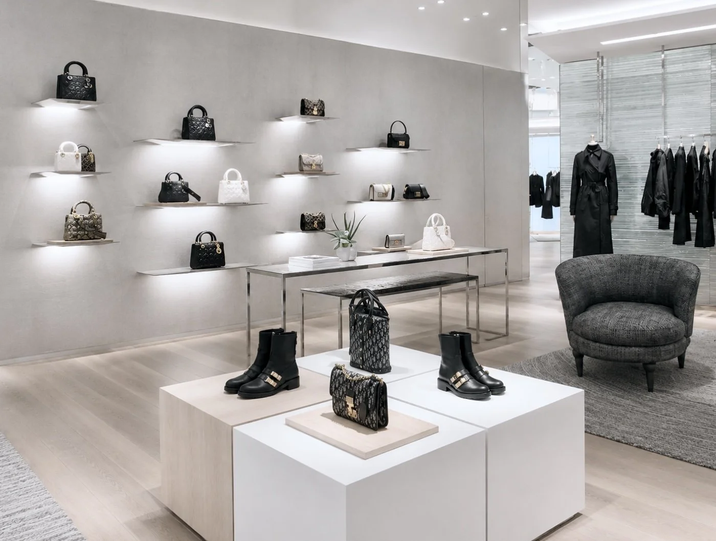 Vitrine d'un magasin de luxe avec sacs à main et bottes en cuir de haute qualité, décor épuré et moderne en tons neutres.