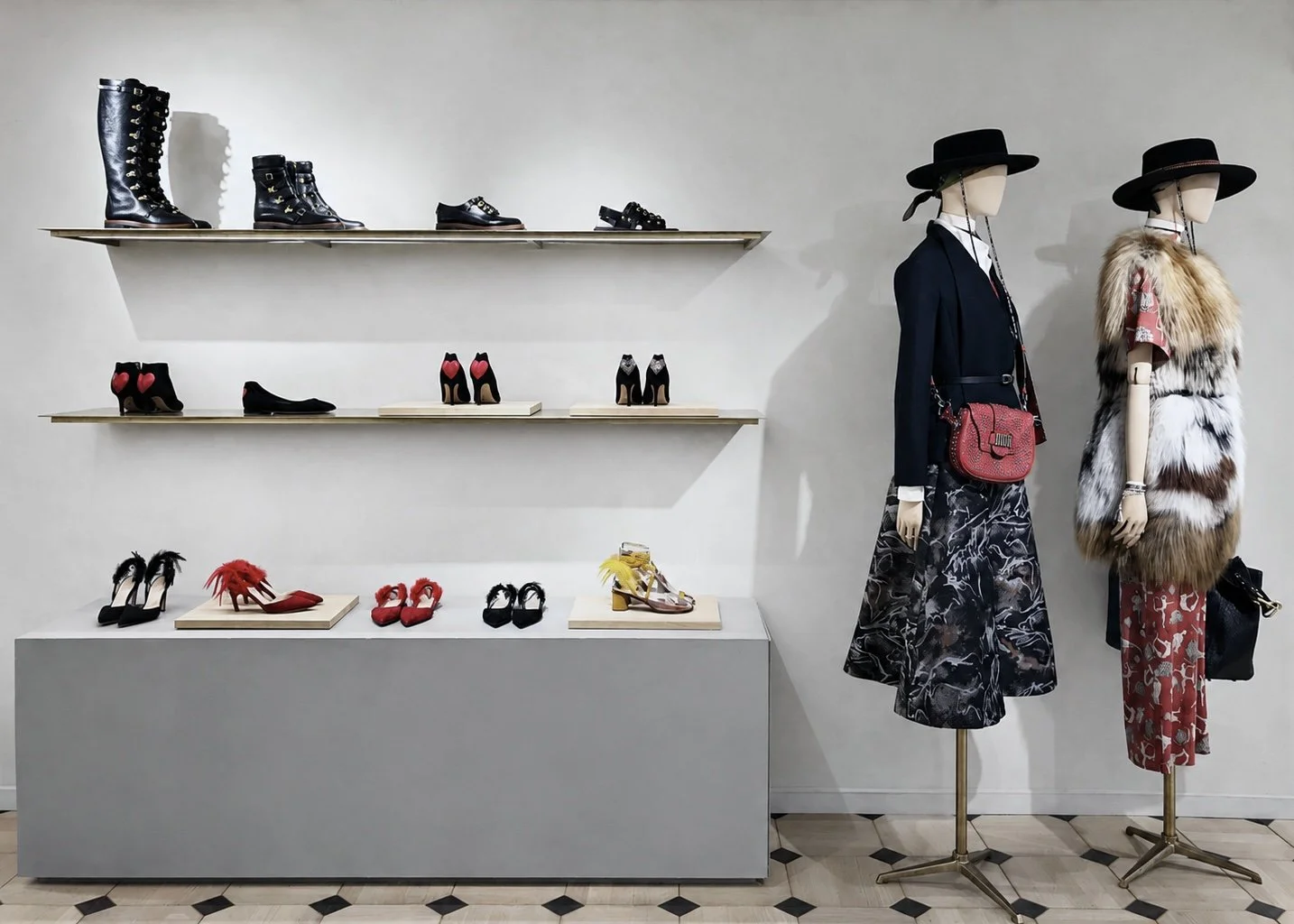 Vitrine de chaussures à talons, bottines et sandales, avec deux mannequins habillés à la mode, portant des chapeaux et des Œuvres d'art. chaussures élégantes sur étagères et mannequins présentant des tenues sophistiquées.