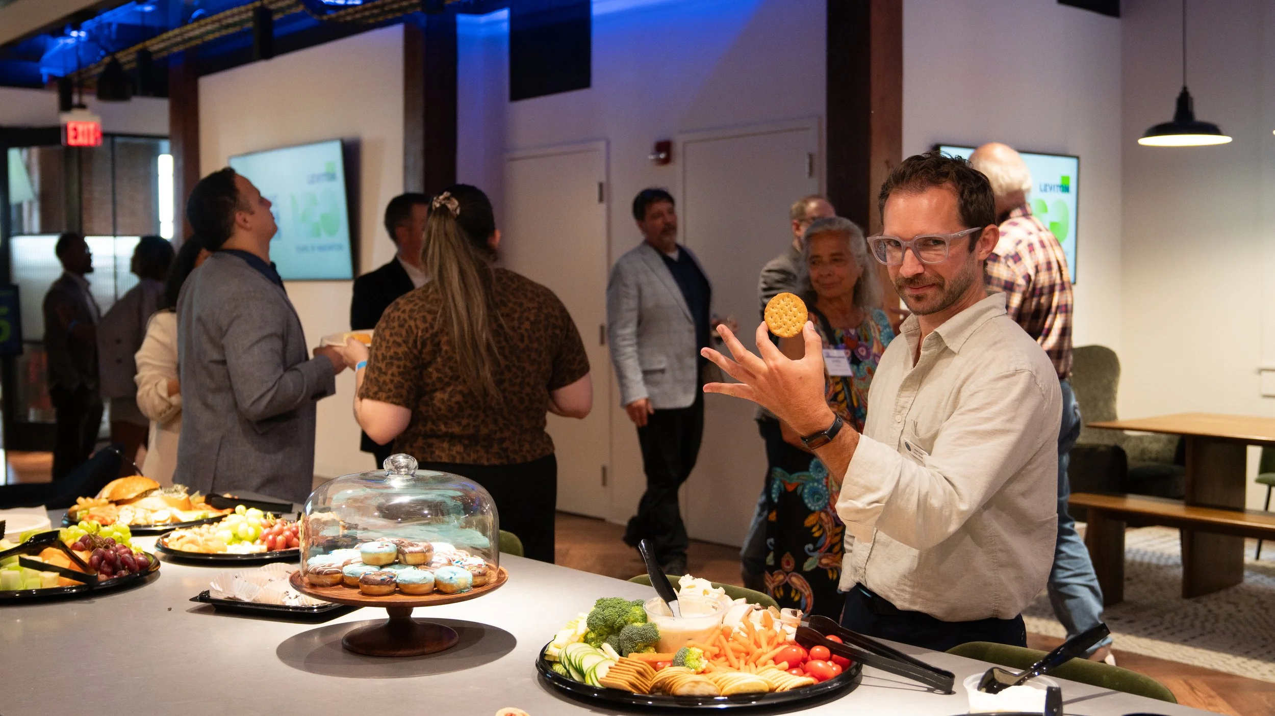 A Civic Design Center employee enjoying the refreshment table at the Civic Design Center's 25th anniversary celebration