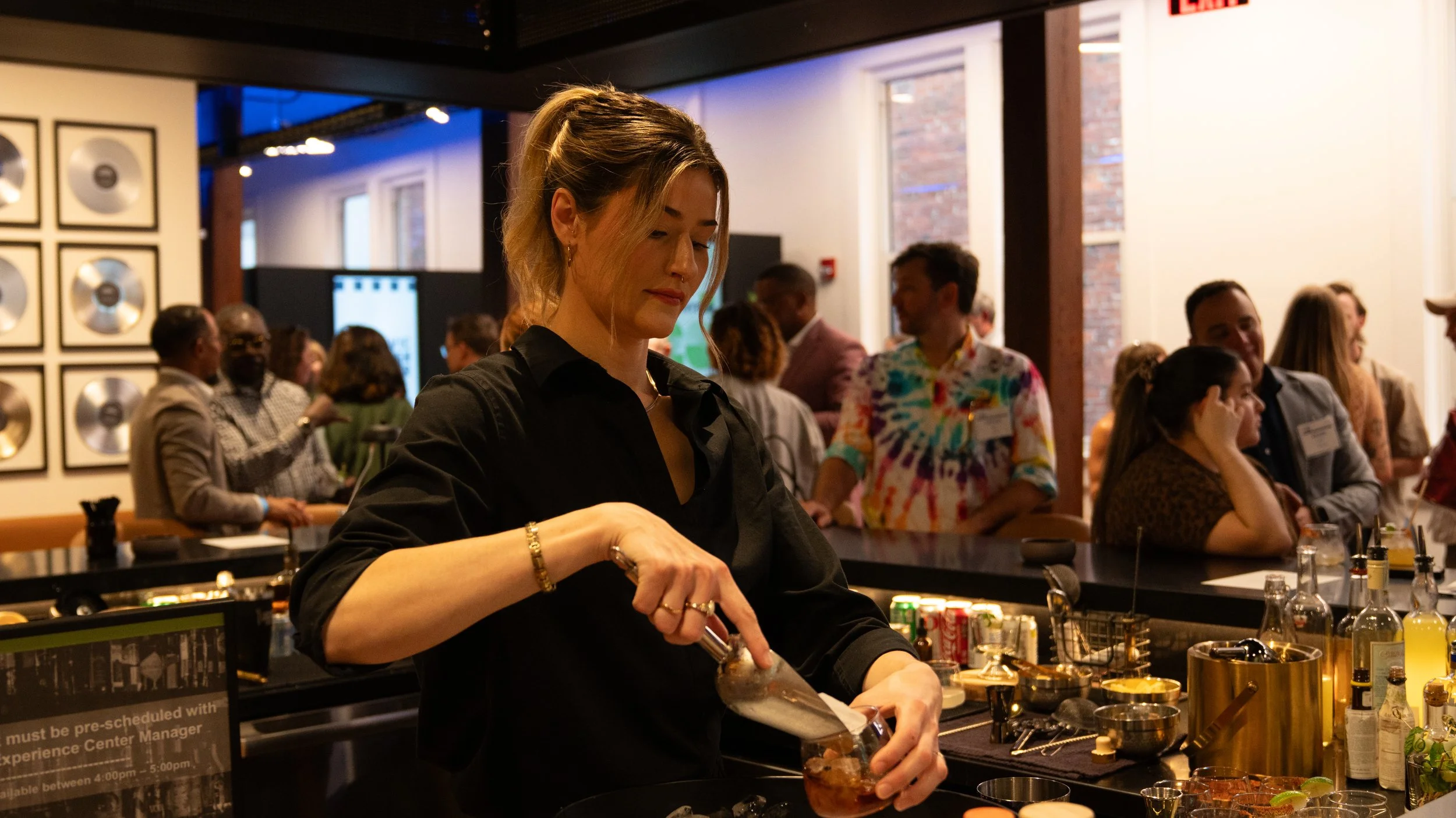 A bar tender preparing drinks for guests at the Civic Design Center's 25th anniversary celebration
