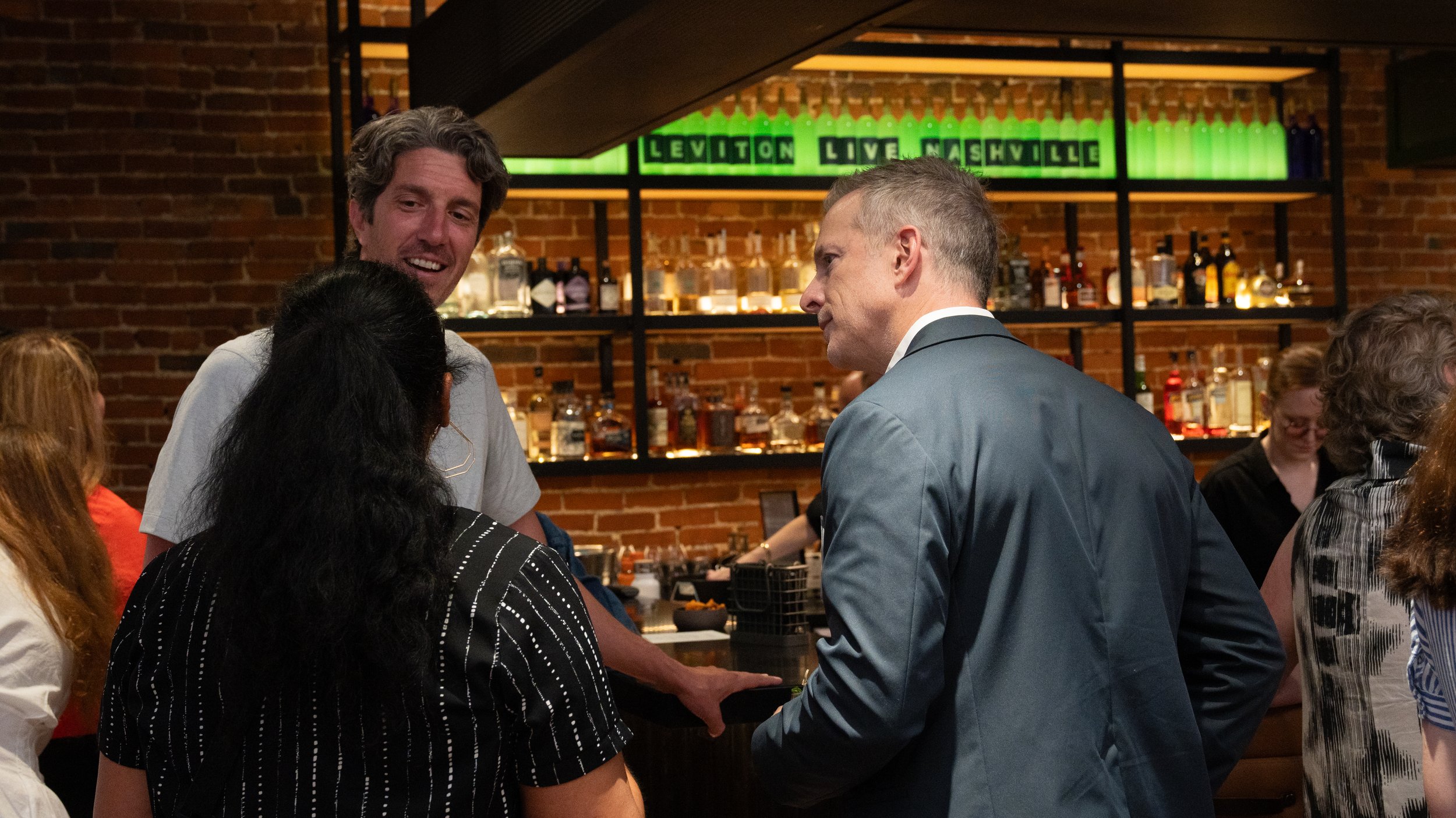 Community members conversing at a bar during the Civic Design Center's 25th anniversary celebration