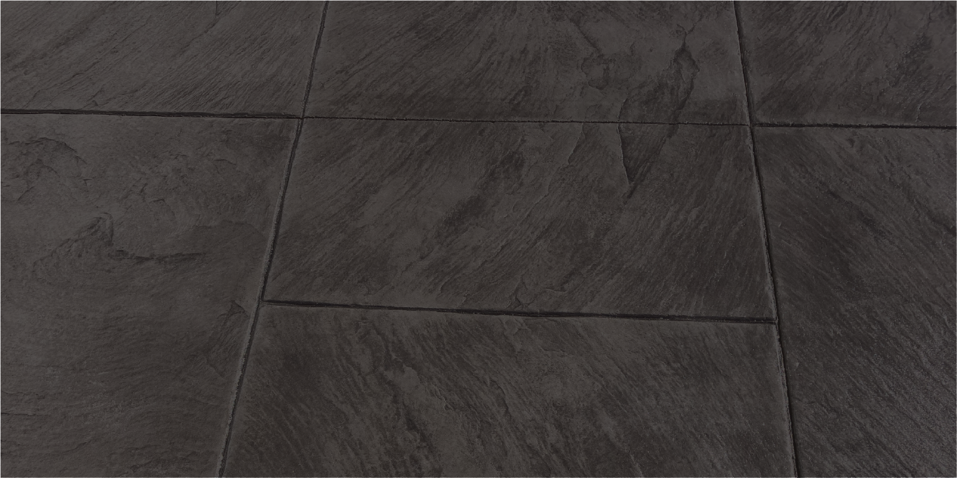 Close-up of dark gray textured ceramic or stone tiles on a floor with grout lines.