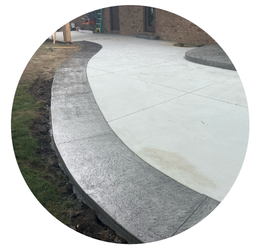 New concrete sidewalk with decorative curved border next to a building entrance.