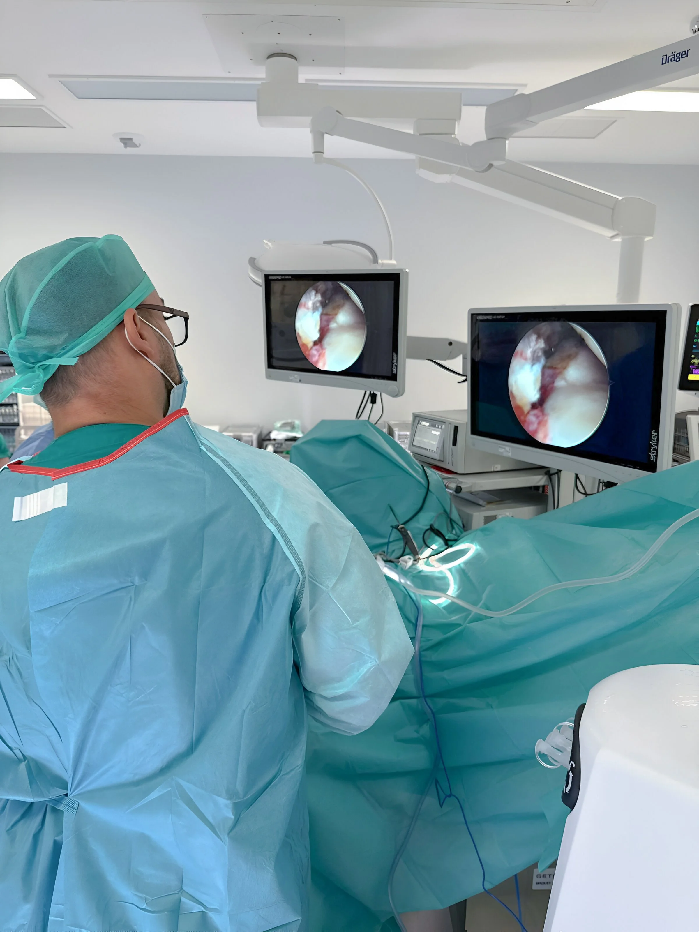 Doctor Gómez en sala de cirugía observando los monitores que muestran una vista interna del cuerpo durante una operación en el Hospital 12 de Octubre, en España