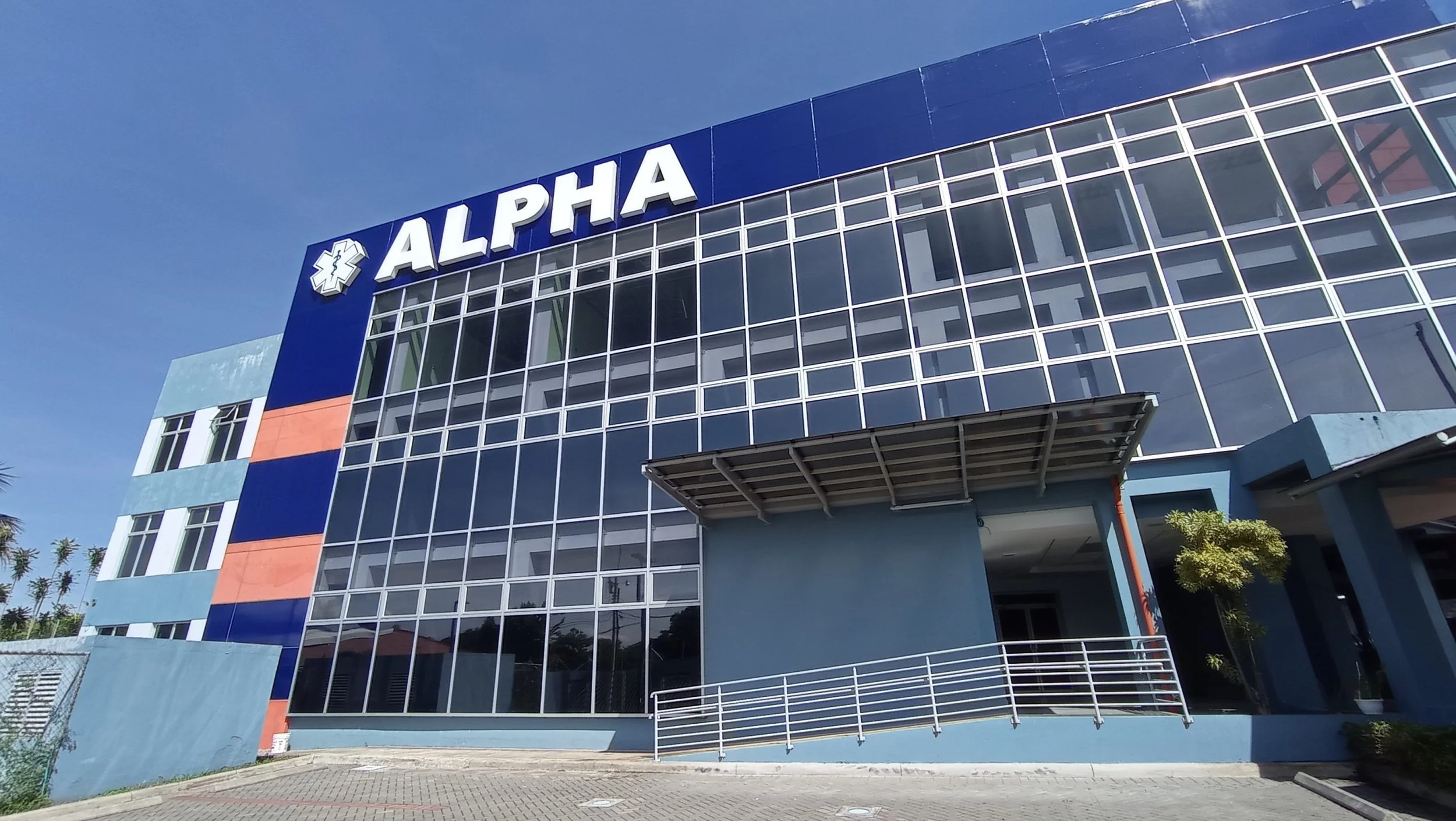 Fotografía de la fachada principal del edificio del Hospital Clínica Alpha en Alajuela, Costa Rica.