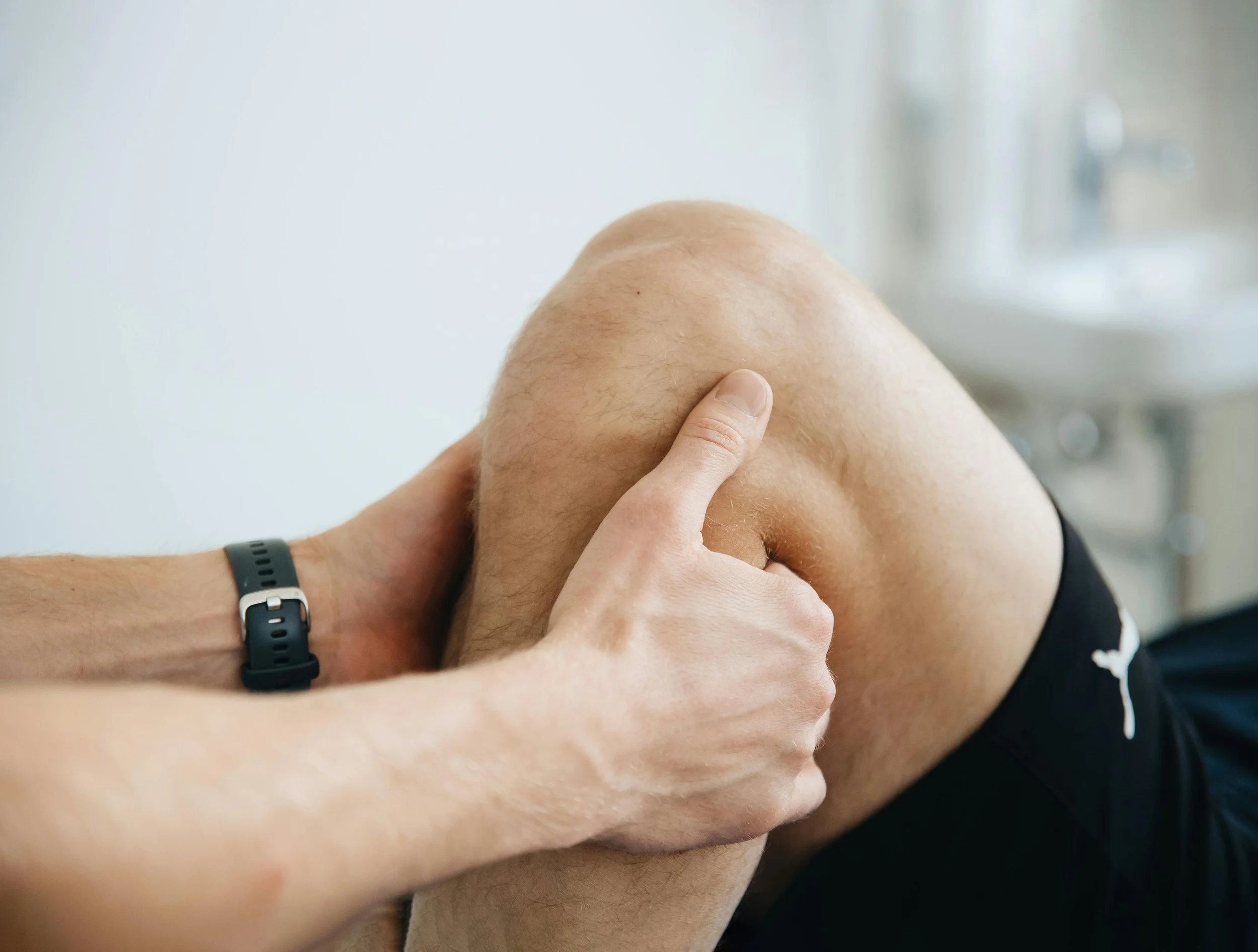 Persona manipulando la rodilla de otra persona en un ambiente clínico