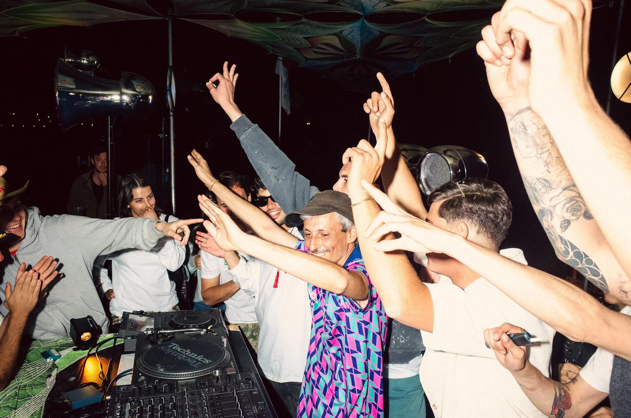 People dancing and having fun at a party with DJ equipment in the foreground