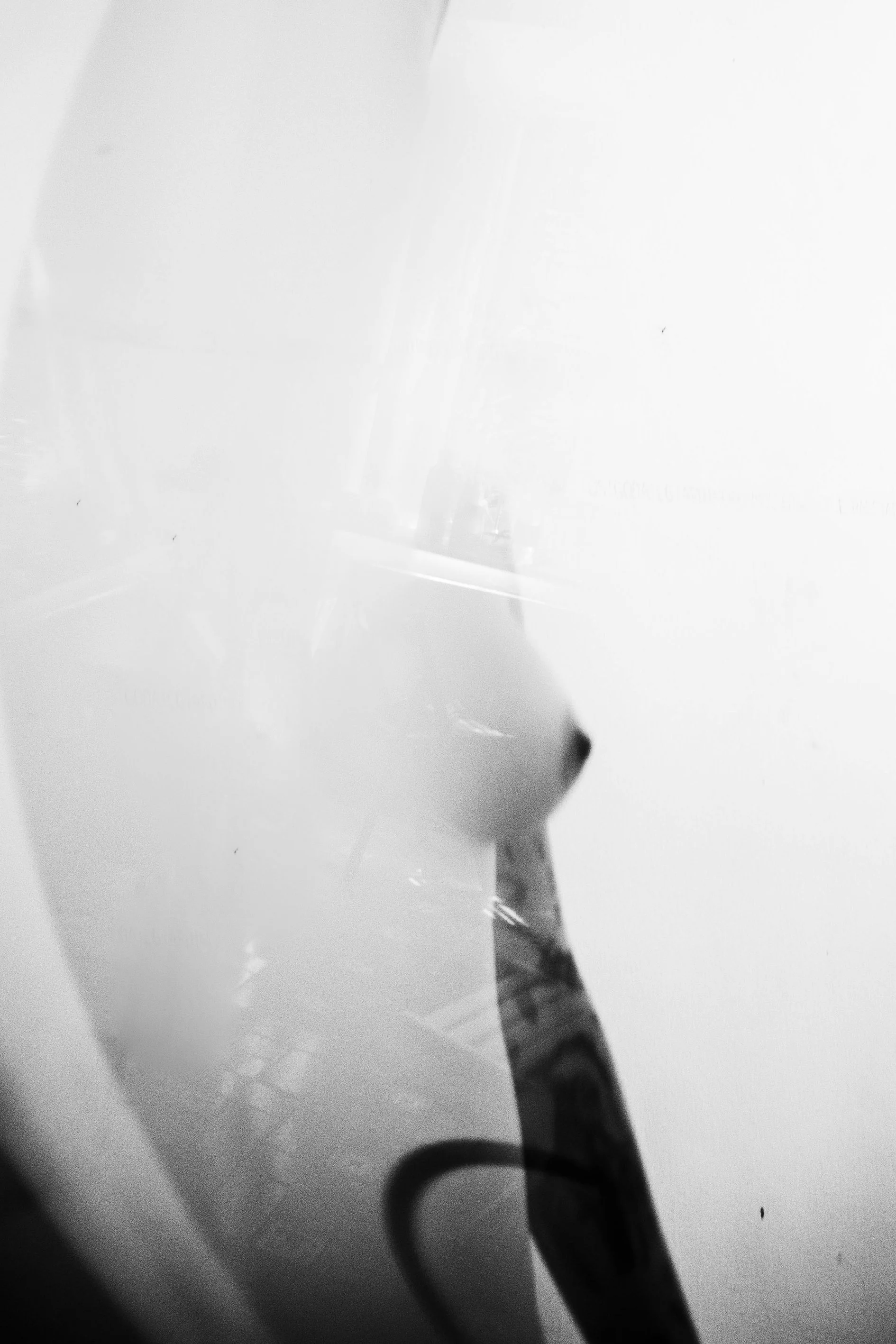 Close-up of a white surface with a reflection showing a black-handled tool or object.